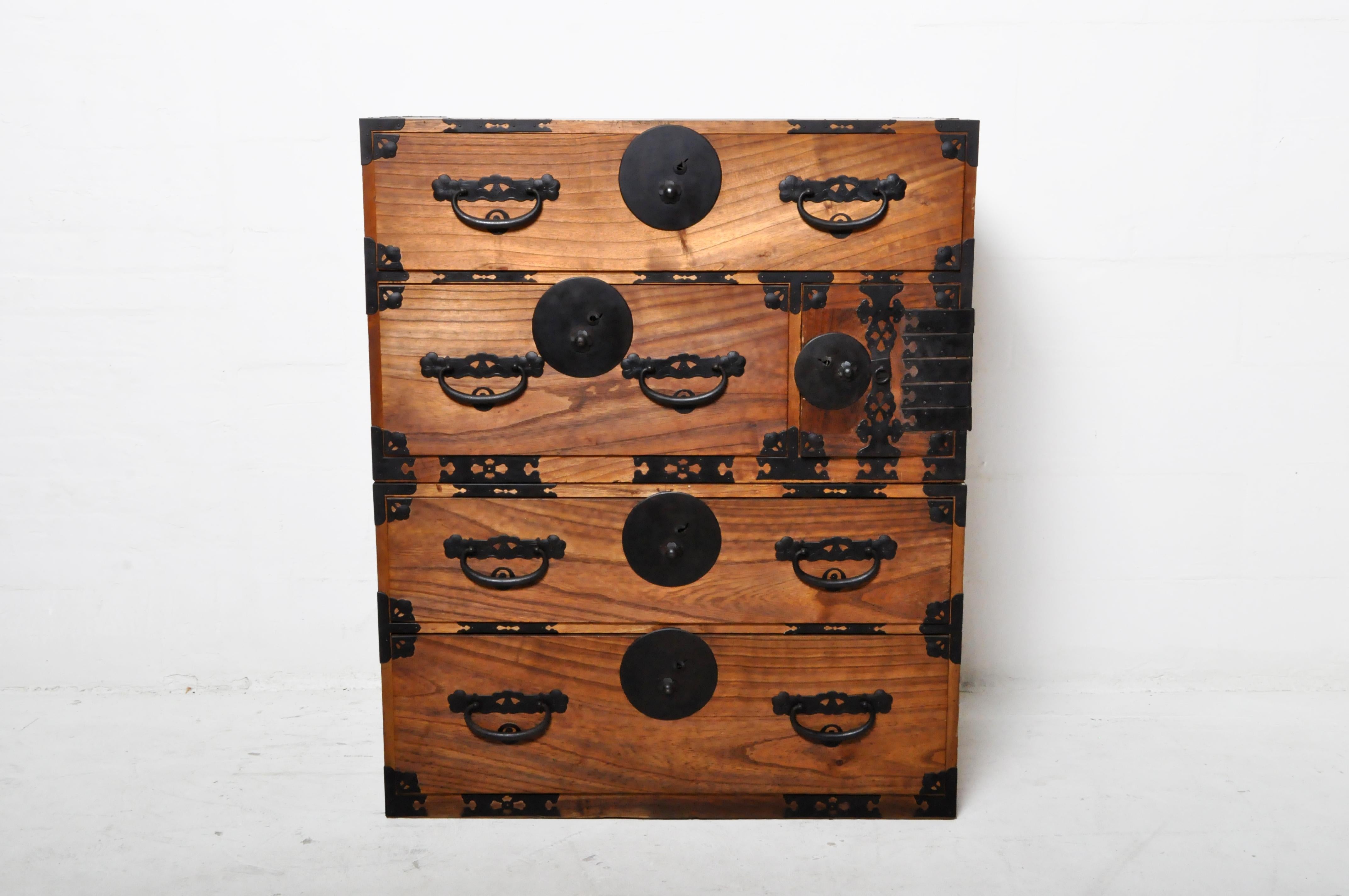 Crafted in Japan during the 20th century, this Kiri wood tansu chest is a fine example of Japan's traditional mobile cabinetry. The long side handles flip up to permit a pole to be inserted so the chest can be carried by two people. This portability