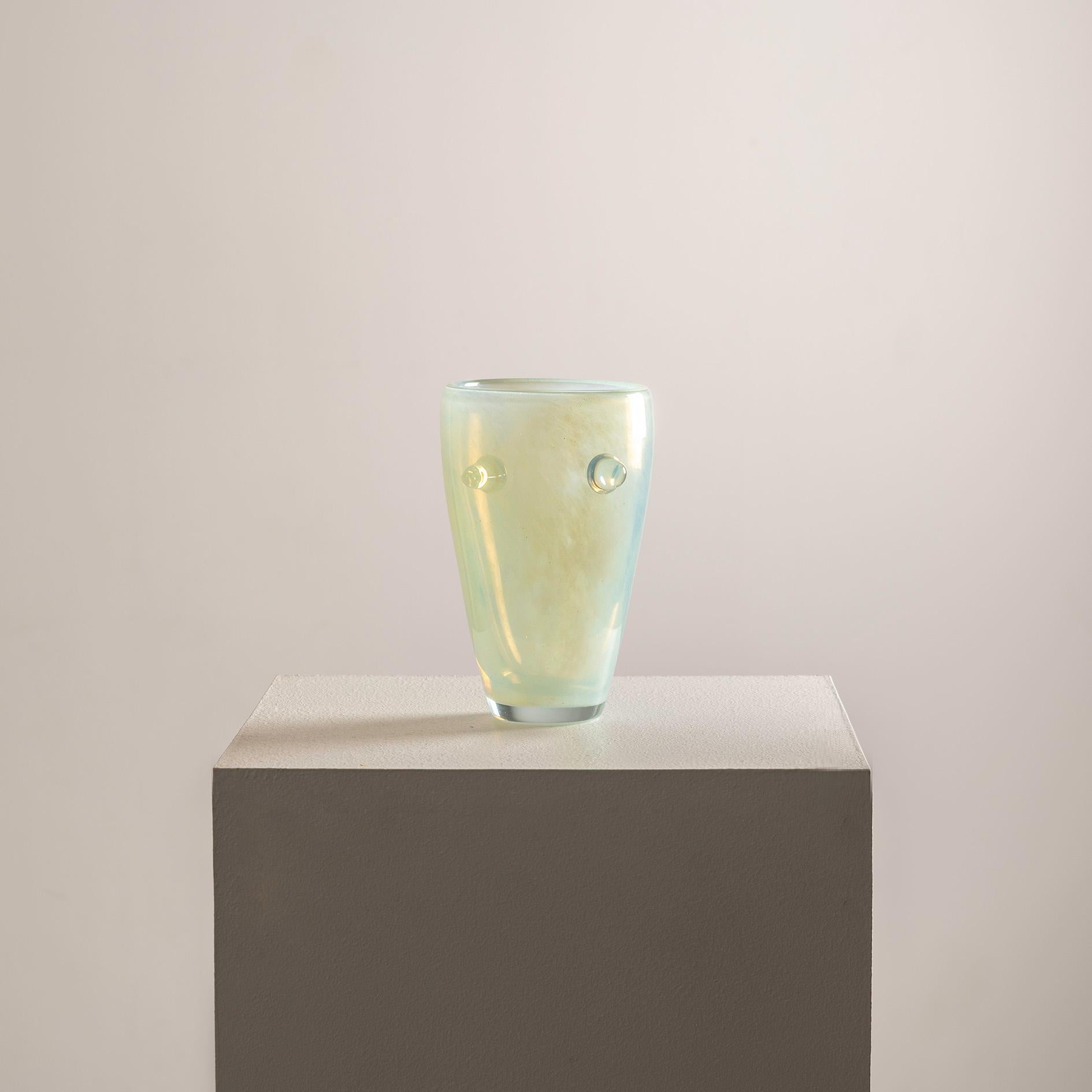Il vaso in vetro artistico opalescente del XX secolo firmato da Henry Dean è un pezzo accattivante che incarna l'eleganza e la maestria di un'epoca passata. Henry Deans, rinomato per la sua squisita lavorazione del vetro, dà un tocco unico a questo