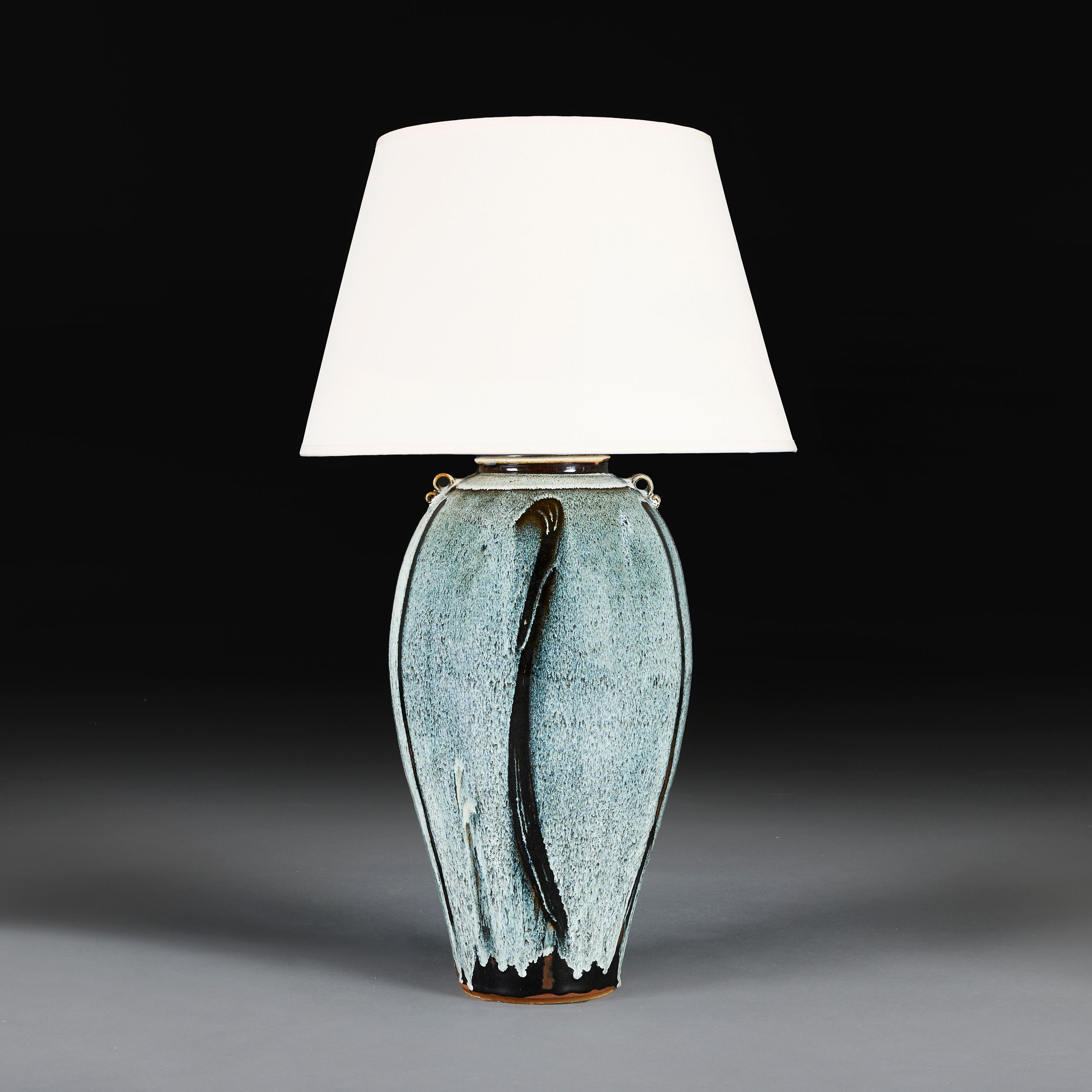 England, circa 1950

An overscale art pottery vase decorated with a blue streaking flambe glaze, now converted as a lamp.

Height of vase   52.00cm

Width of body   24.00cm

Please note:

Lampshade not included. Lamp photographed with a 18” diameter