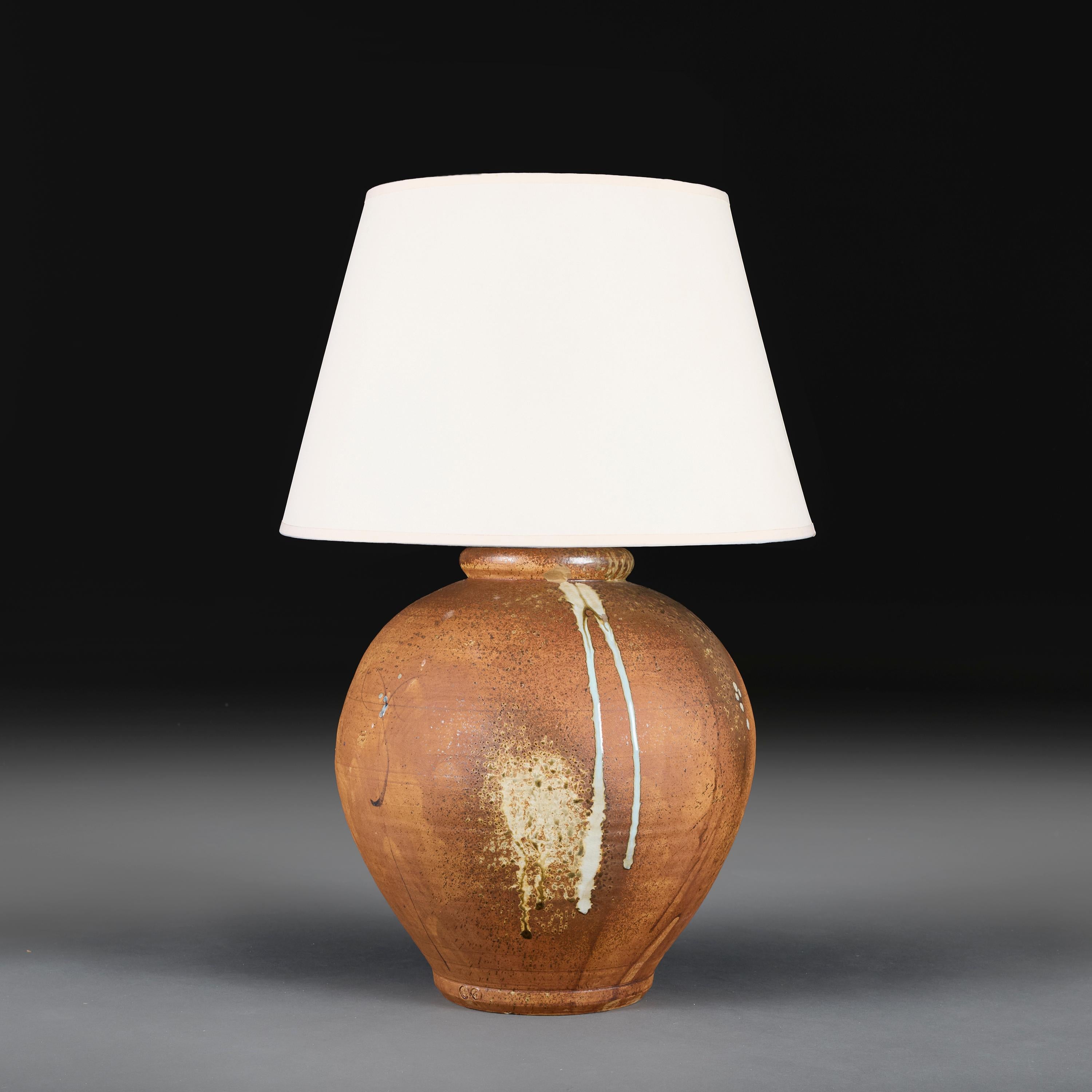 England, circa 1940

A large bulbous terracotta vase with areas of salt glaze decoration and drips to the rim, now converted as a lamp.

Height 38.00cm

Diameter 35.00cm

Please note:

Lampshade not included. Lamp photographed with a 18” diameter