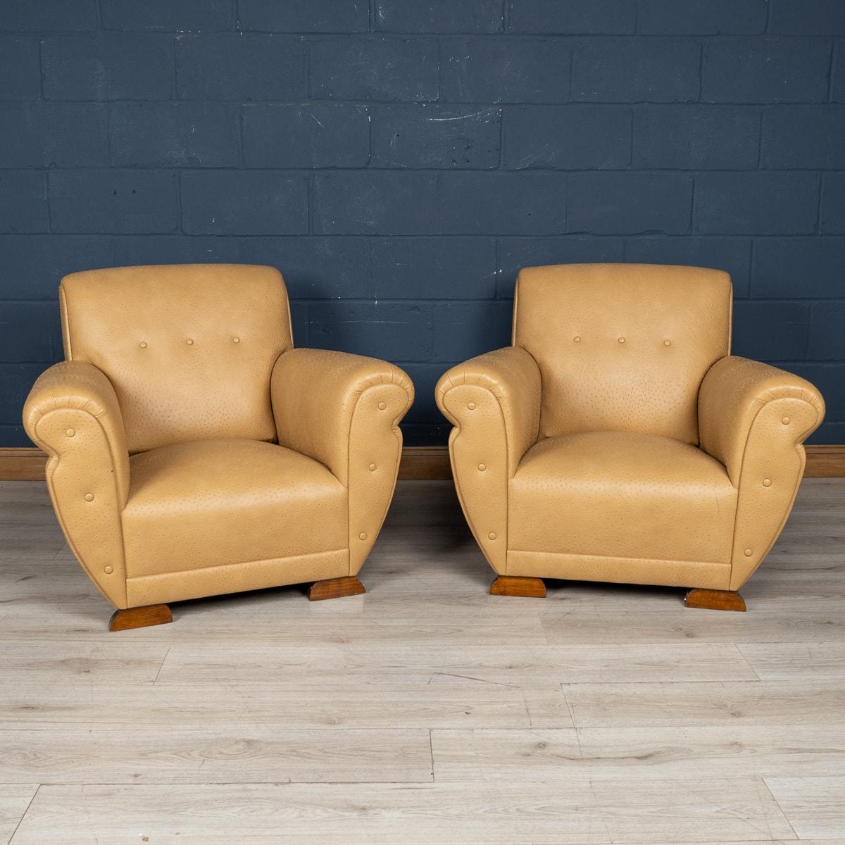 Transport yourself back to the swinging 1960s with this stunning pair of armchairs exuding English charm. Upholstered in sumptuous faux ostrich skin leather, these armchairs boast a luxurious texture that adds a touch of opulence to any interior