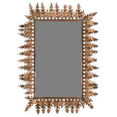Un espejo español del siglo XX con motivos de hojas de bellota, fabricado en cobre estampado