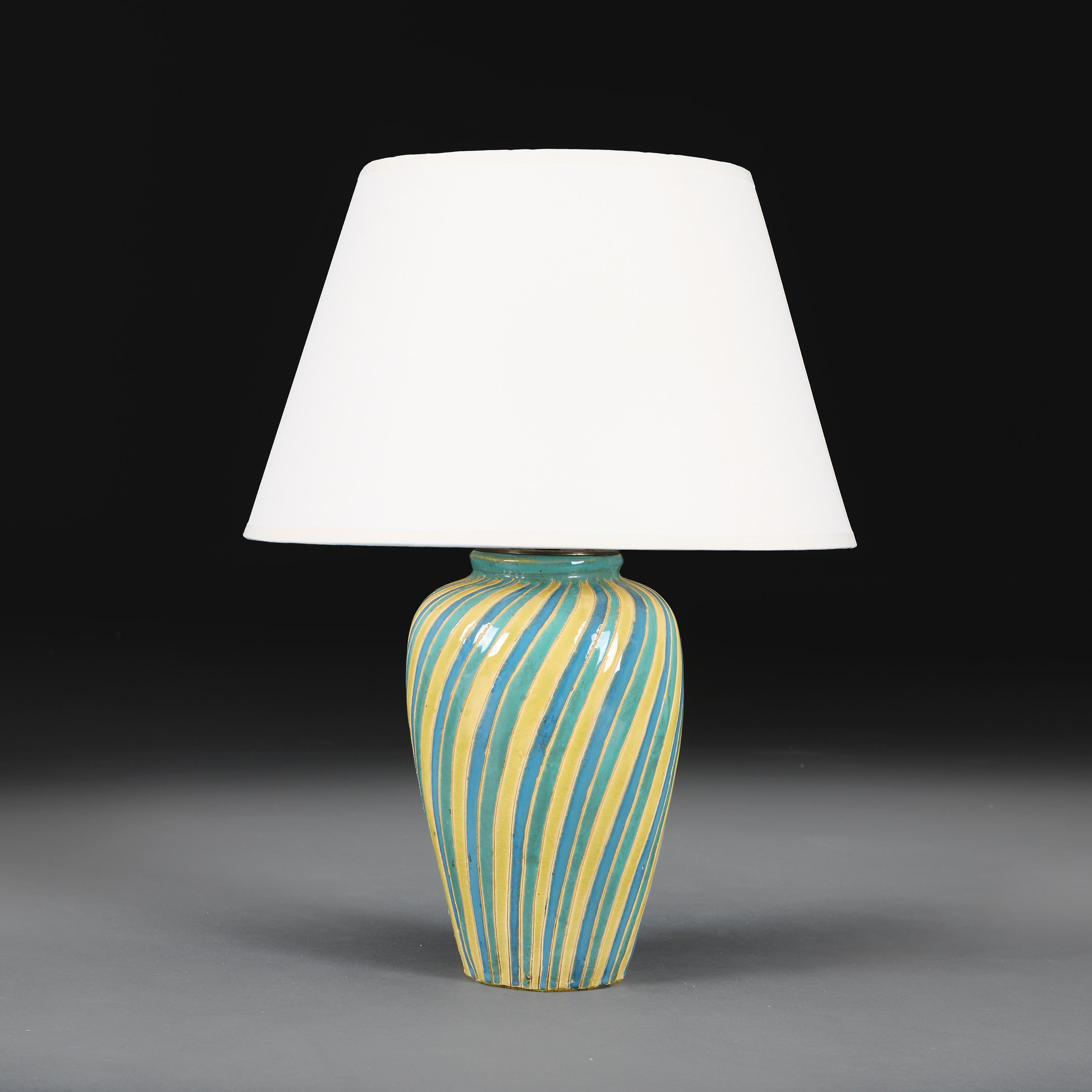 England, circa 1960

An art pottery baluster vase decorated with swirling stripes of blue, green and yellow tin glaze, now converted as a lamp.

Height of vase 26.00cm

Width of body 15.00cm

Please note:

Lampshade not included. Lamp photographed