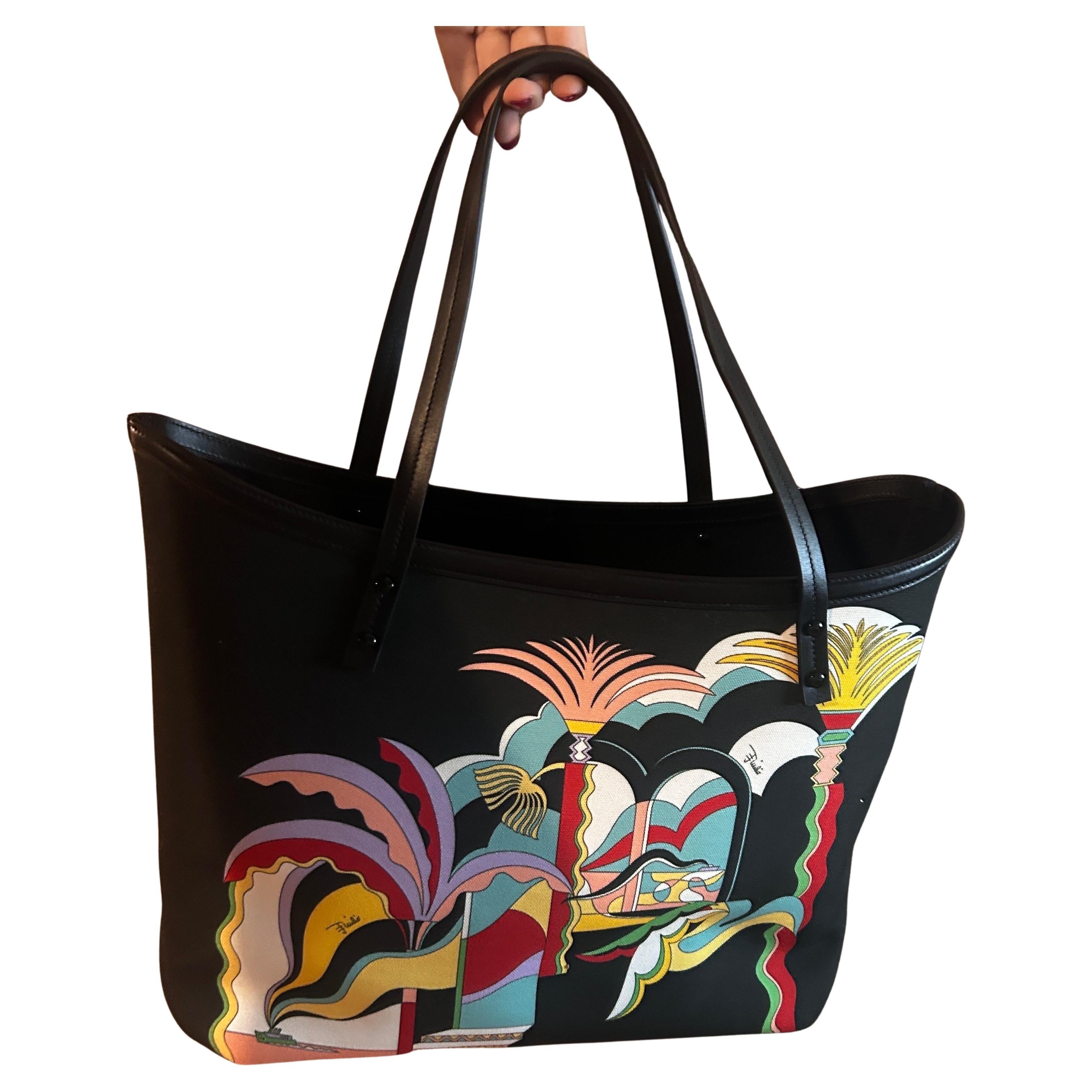 This bag by Emilio Pucci showcases the brand's signature style, known for its vibrant colors and bold, graphic prints. The tote features a black background adorned with a lively and abstract design, which incorporates a mix of geometric and organic