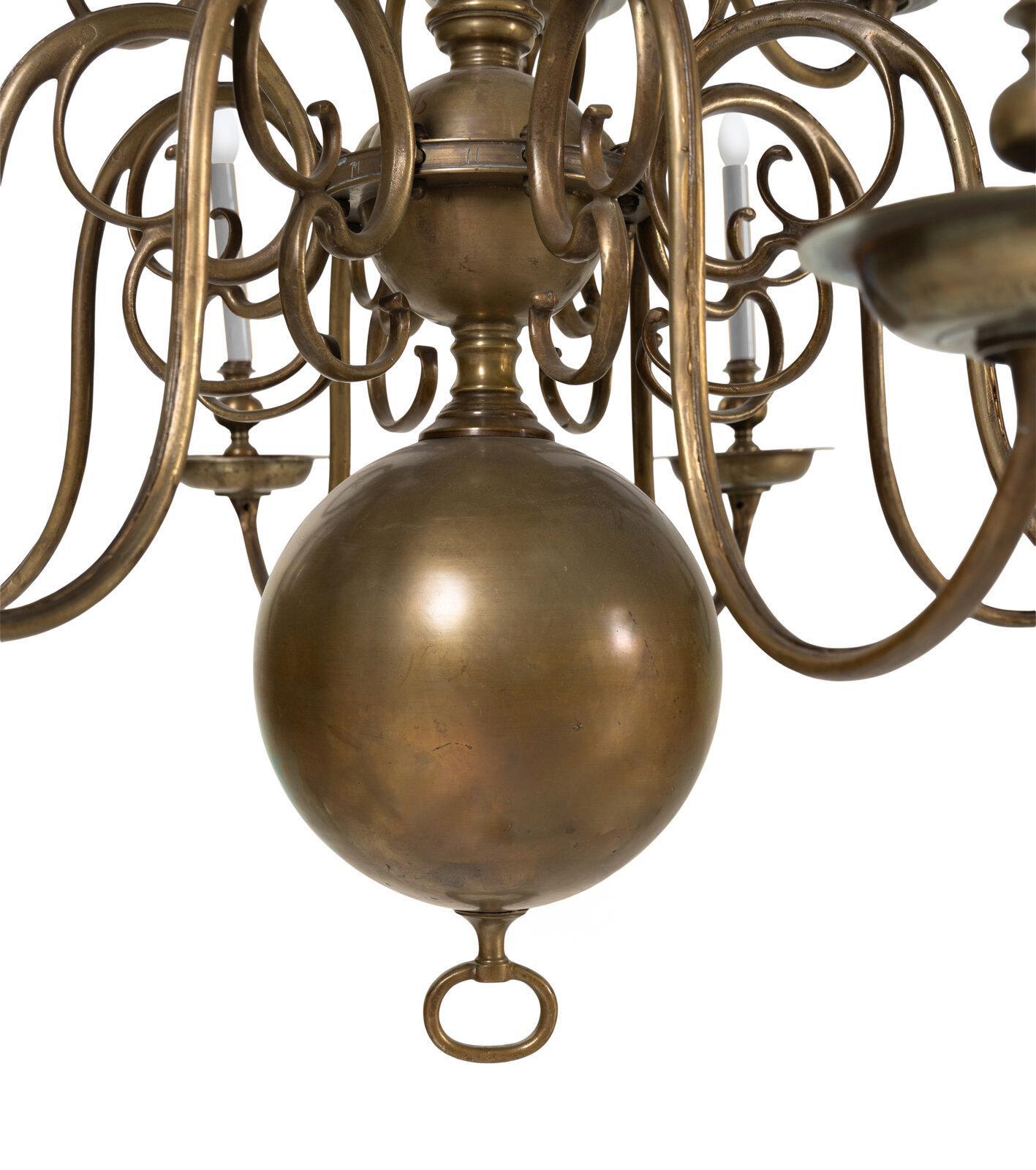 Un lampadario barocco olandese in ottone con ventiquattro luci disposte su tre livelli graduali. I bracci a scorrimento e i componenti torniti sono finemente fusi. La calda patina dell'ottone invecchiato aggiunge profondità e presenza alla