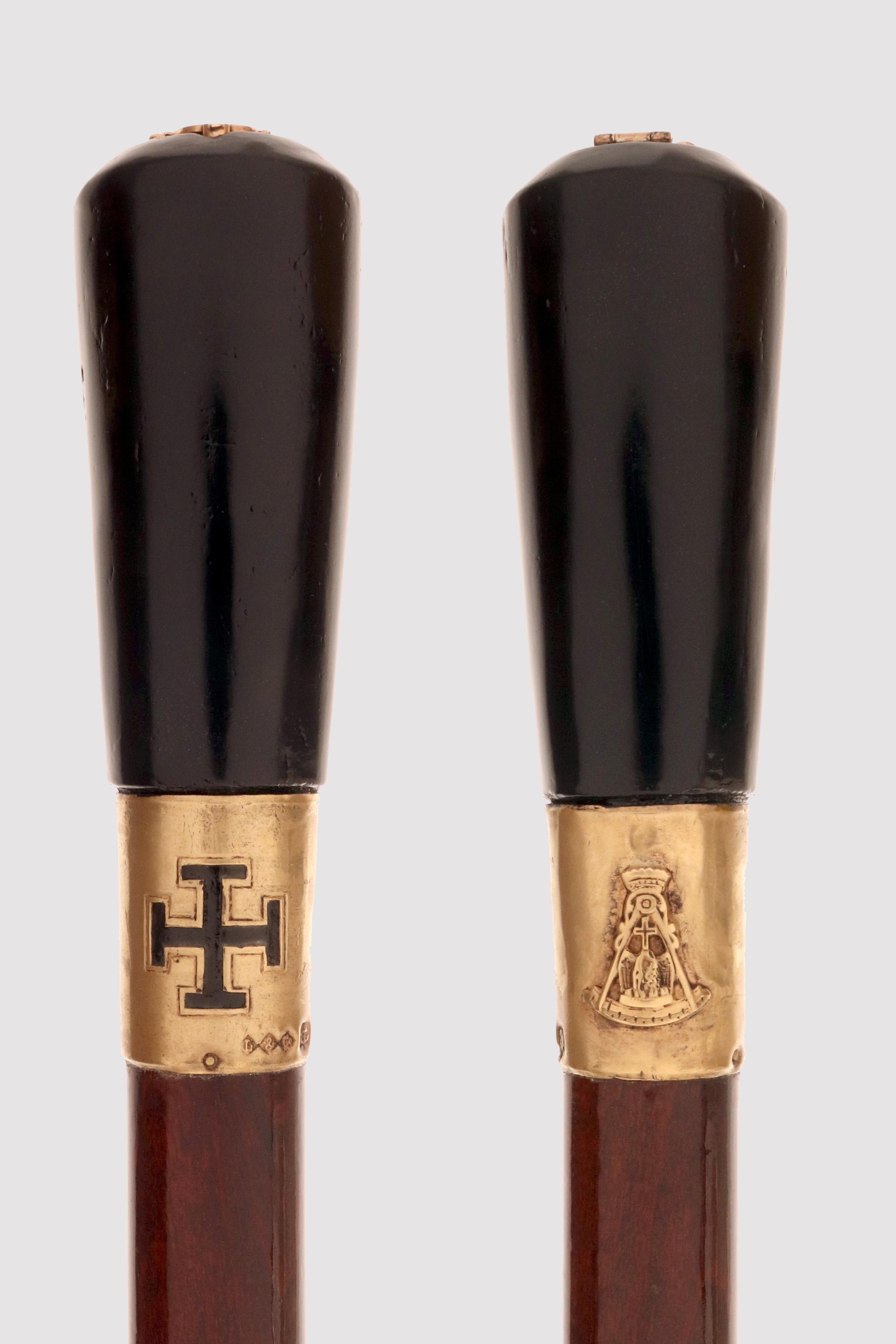 Bastón masónico del rito escocés L, grado 32. El asa tiene forma de milord en ónice negro, con un escudo de armas abrible de oro de 14 quilates y esmaltado en forma de cruz con un águila bicéfala, superado por el número 32. La banda de plata dorada