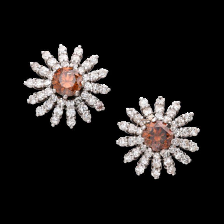 Each centering a brown diamond, surrounded by 42 round diamonds. 
- Brown diamonds weighing a total of approximately 2.00 carats
 - Diamonds weighing a total of approximately 2.25 carats
 - 18 karat white gold
 - Length 3/4 inch, width 3/4 inch 
-