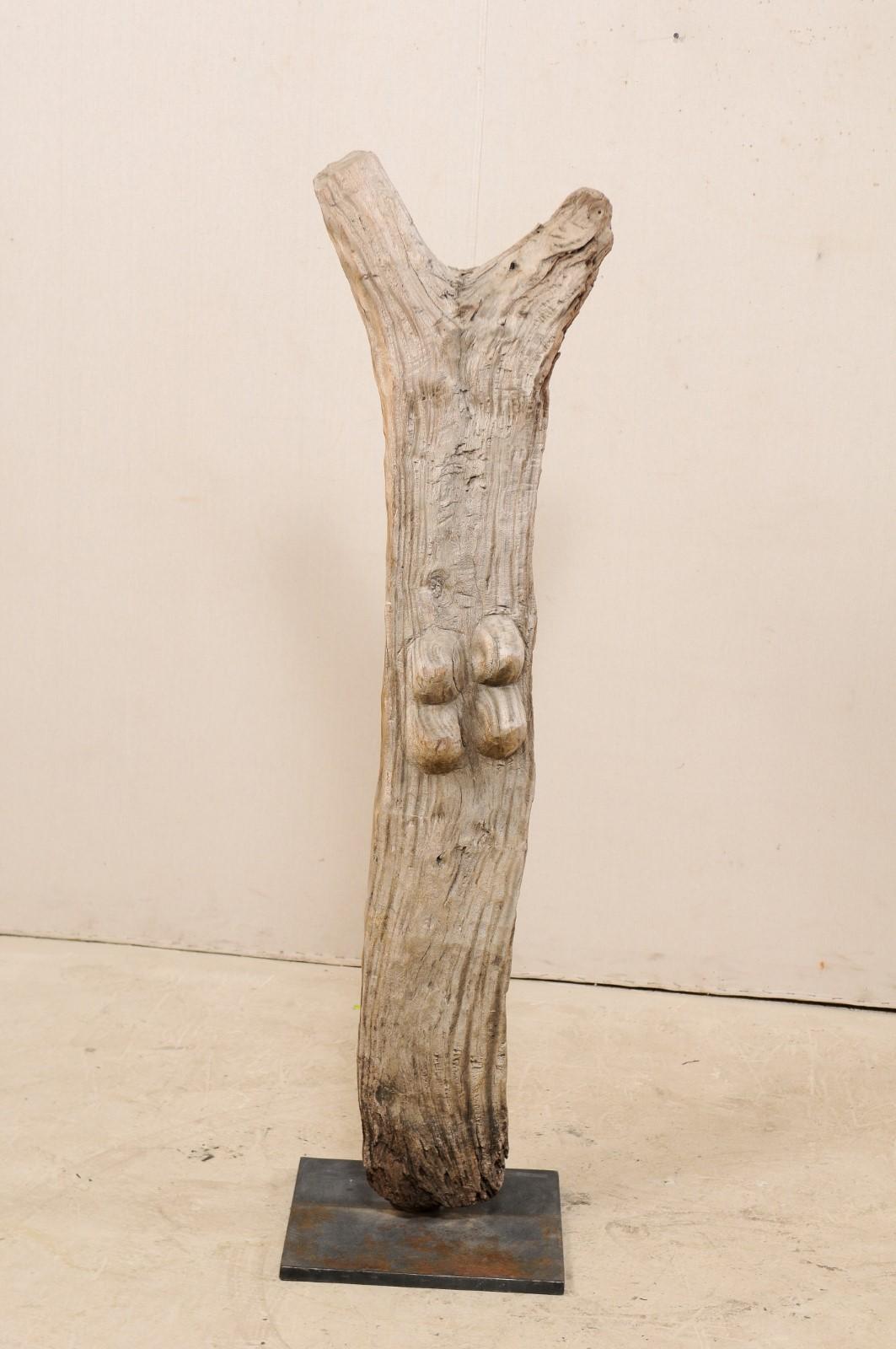 An early to mid-20th century Toguna support post from the Dogon Tribe of Mali, on custom metal stand. This West African hand-carved wooden bean was originally used for supporting the 
