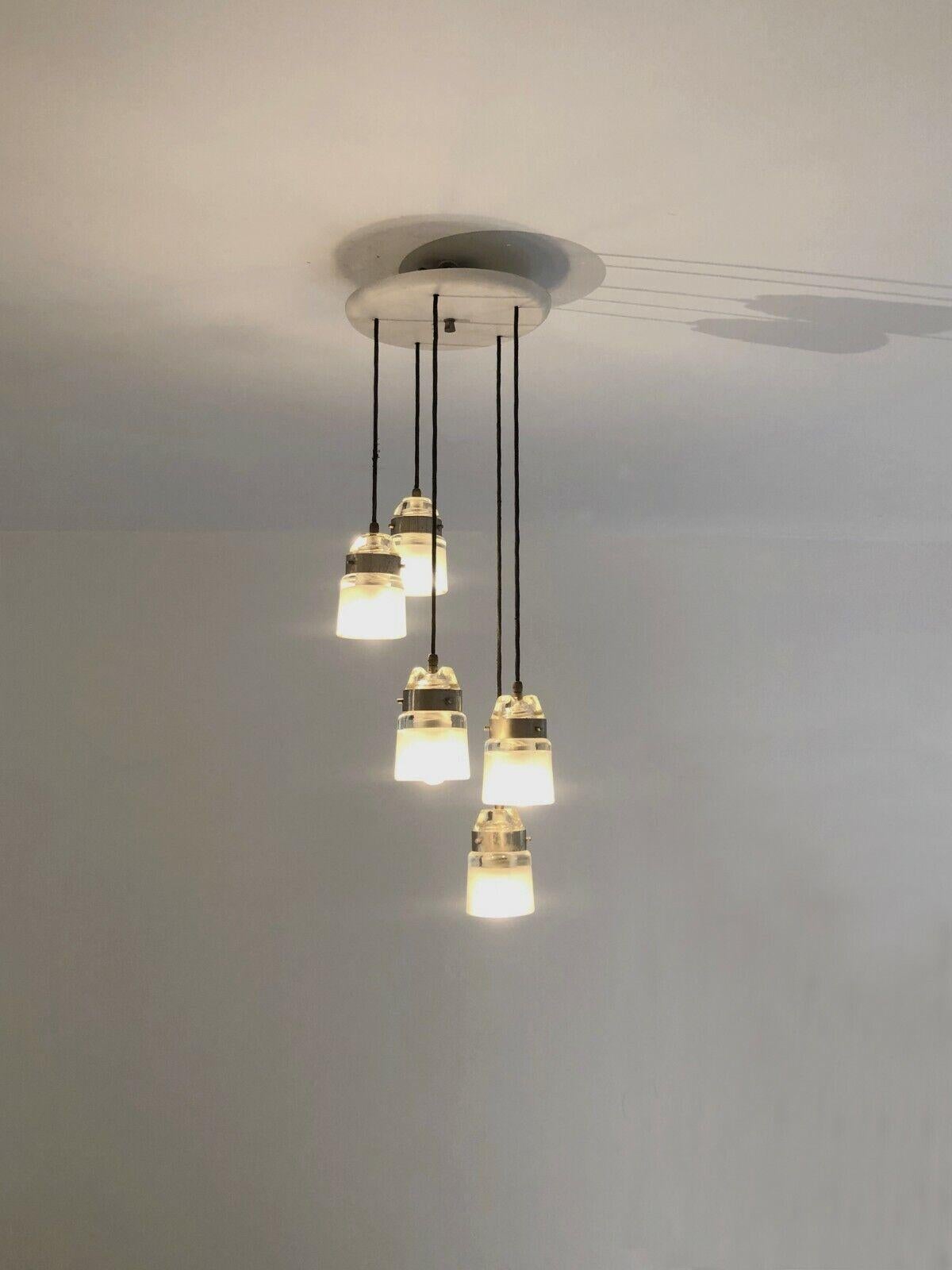 An elegant 5-light cascading suspension, Modernist, Minimalist, circular base in off-white lacquered metal, 5 suspensions forming a cascade of lights in black woven threads and thick sandblasted glass, to be attributed, Italy 1960.

The length of