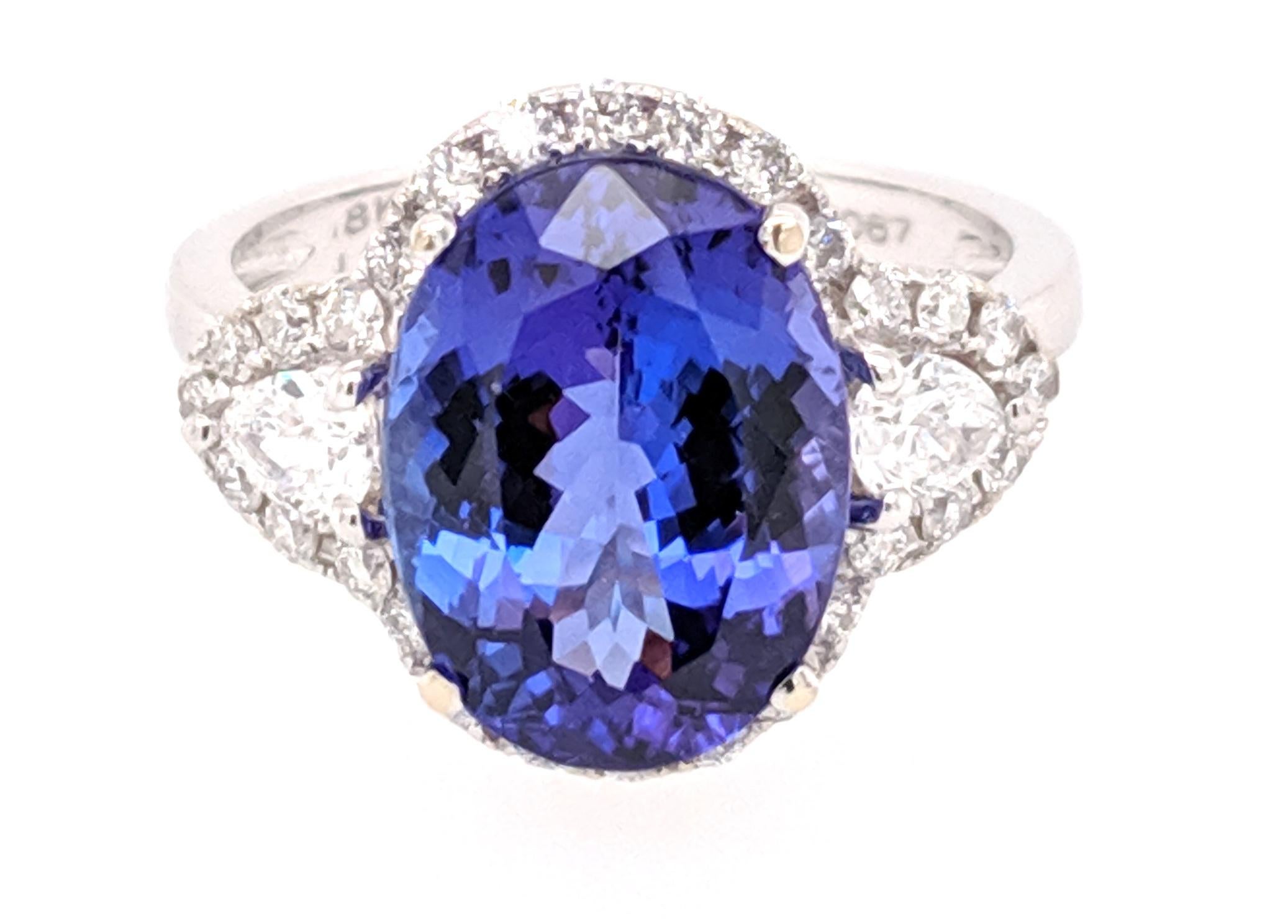 The Cocktail Ring is crafted in 18k white gold and features (1) oval Tanzanite weighing 5.32ct and is flanked by (2) pear shaped diamonds weighing approximately .29cttw with a color of G/H and a clarity of SI1 to SI2. There are also (50) round