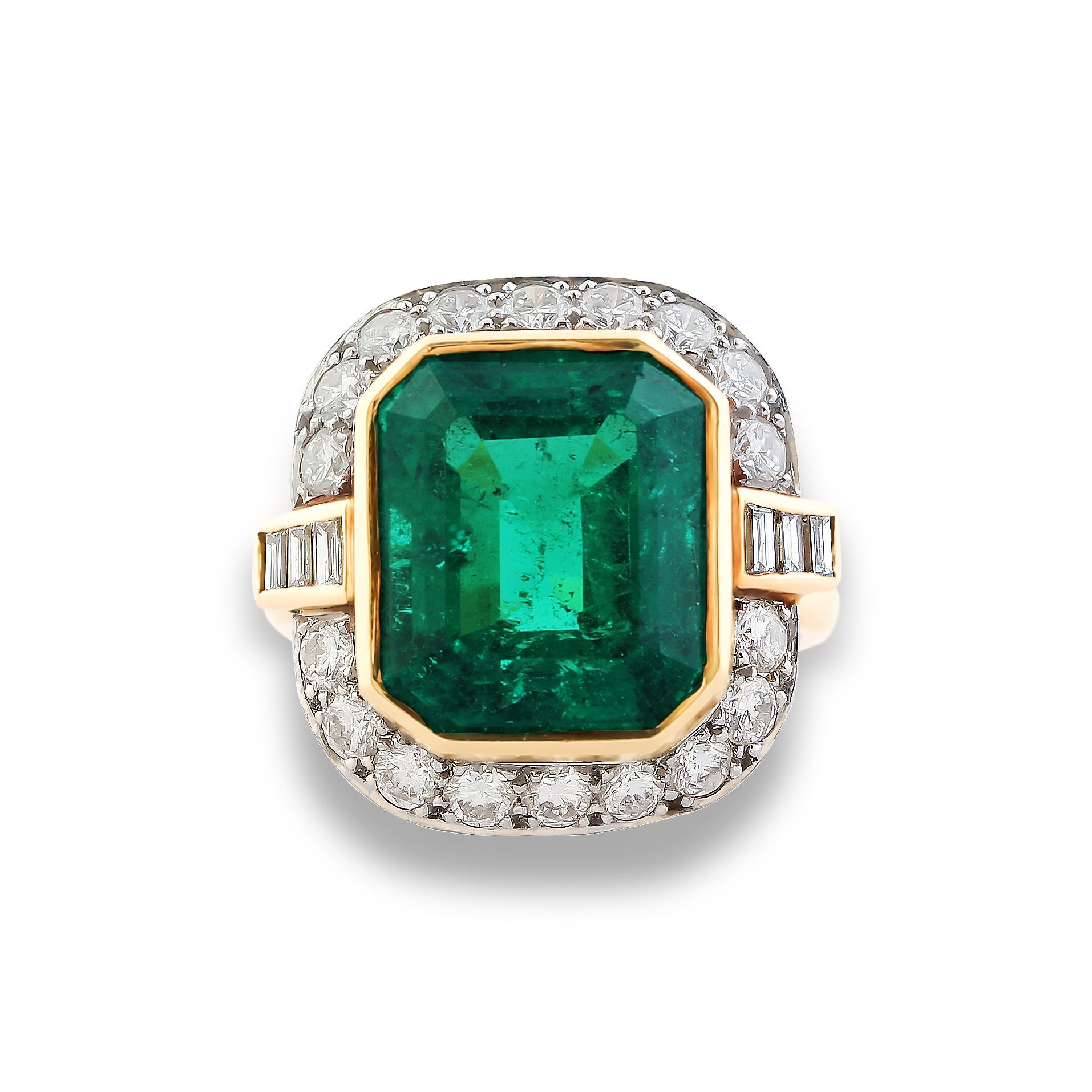 An elegant emerald and diamond engagement ring, set at the centre with a 7.20 carat emerald-cut Colombian emerald in a surround of round brilliant-cut diamonds and flanked by baguette-cut diamonds. Mounted in 18k yellow gold, circa 1960s. This piece