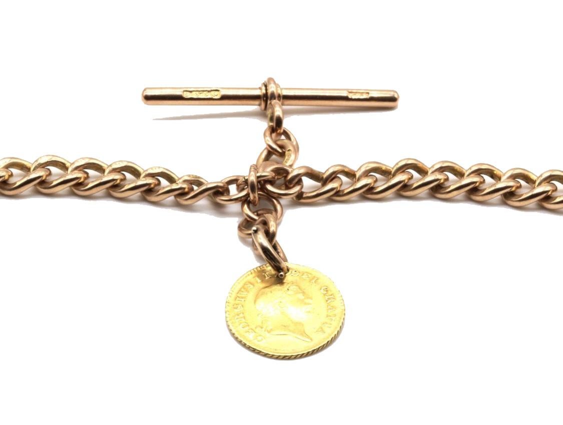 A 9 Kt rose gold double albert gentleman's pocket watch chain with T bar and swivel fittings with a George III 1810 one third of a guinea 18 Kt gold fob. 
The double graduated curb link chain marked 9 kt on all the links, T bar and lobster swivel