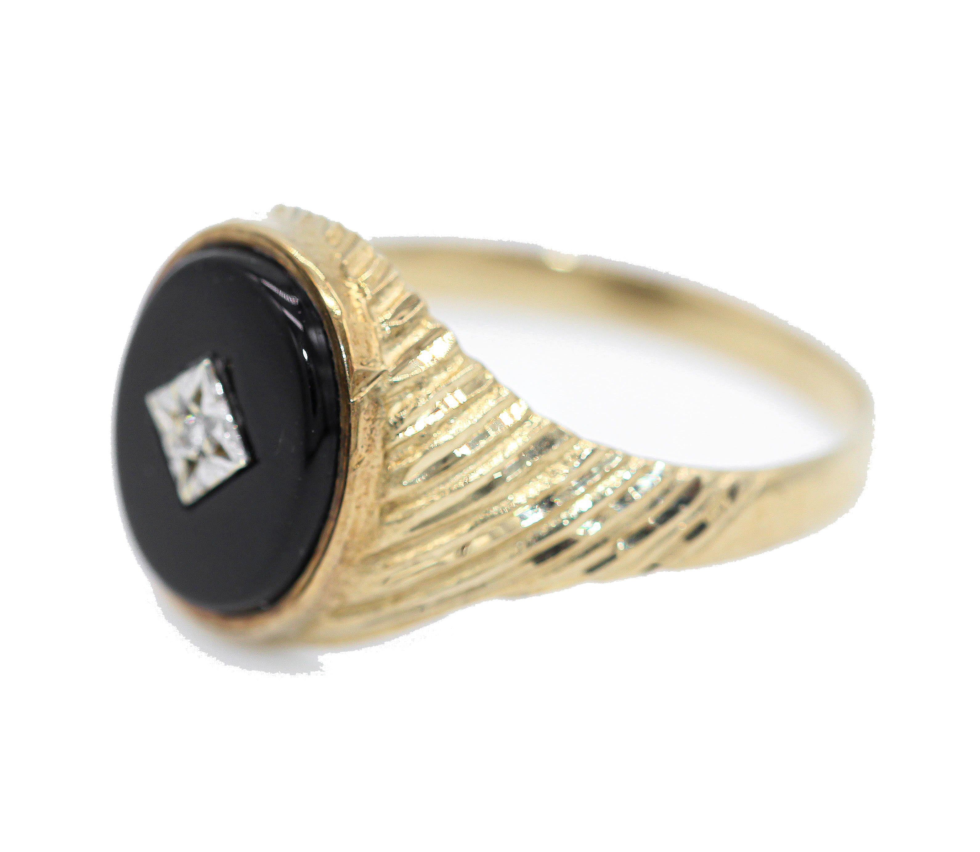  A 9 kt Yellow Gold, Onyx and Diamond Gentleman's Signet Ring with Oval Face. The central diamond in a square white gold setting on a black onyx oval and with ridged shoulders.
Hallmarked Birmingham 1964
UK  Size  X
USA  Size  12.5
