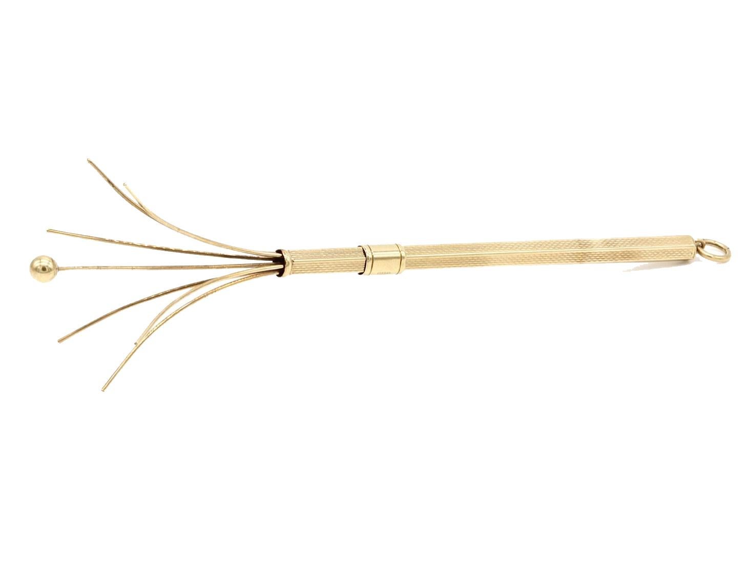 A 9 Kt yellow gold propelling swizzle stick cocktail stirrer. The octagonal body with engine turned decoration and sliding mechanisn, suspended by a fob ring.
Hallmarked Birmingham 1954. Maker WM Ltd.