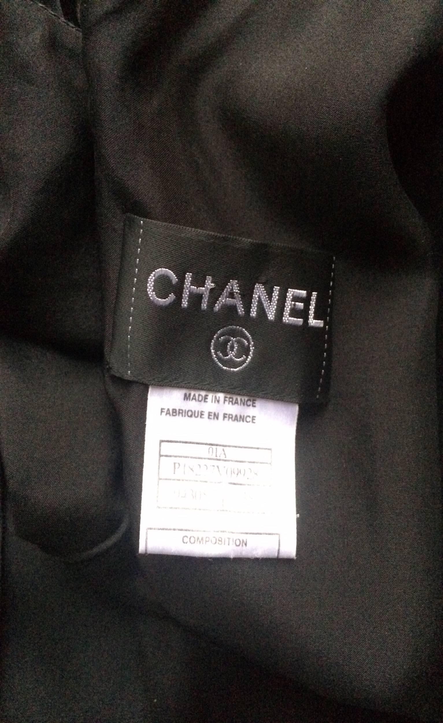 A fabulous 1990s black Chanel silk satin sleeveless cocktail dress with a nipped in waist and beautifully pleated skirt. The dress closes in the back with a row of Chanel double 'C' logo buttons. 

This item is in overall very good vintage