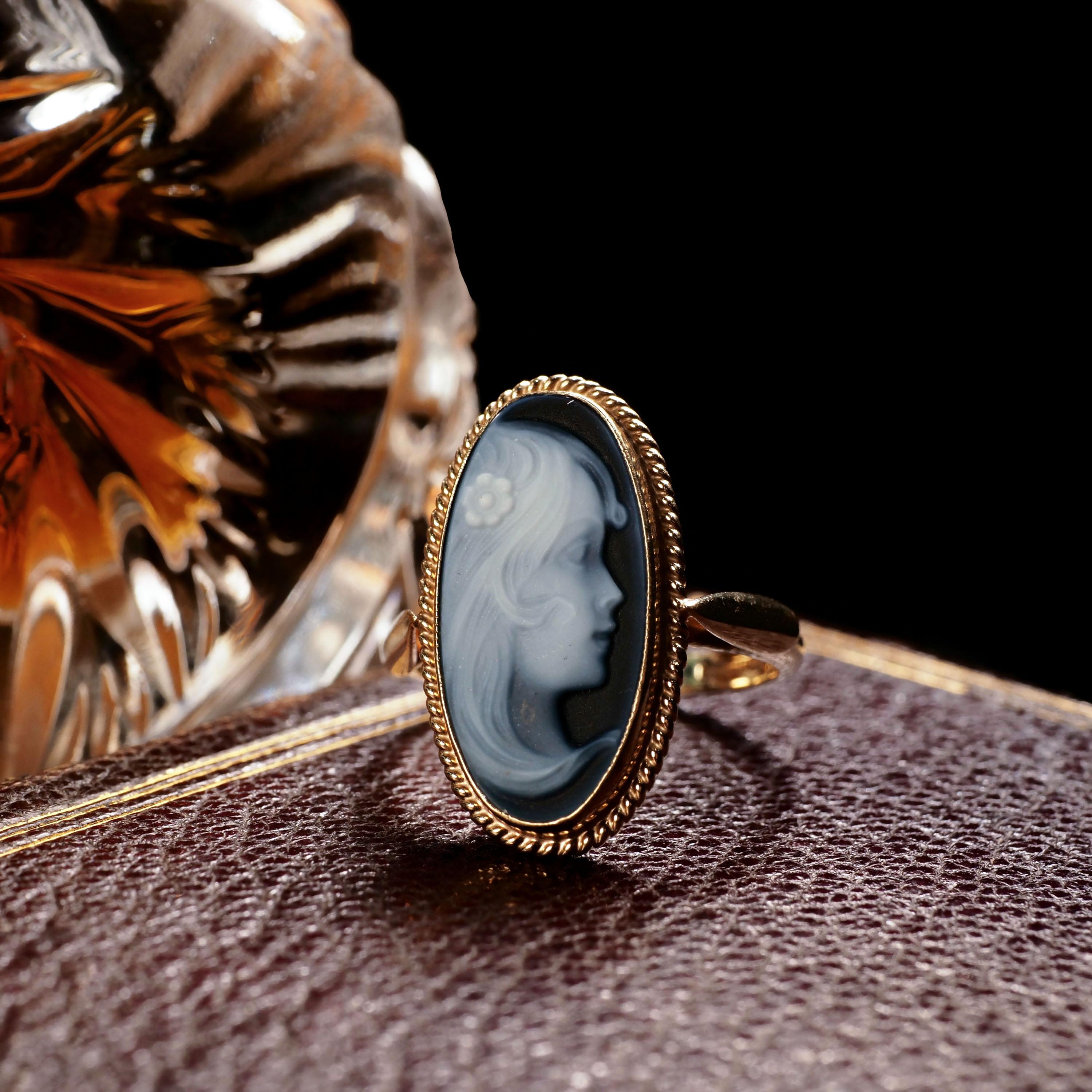 We are delighted to offer this wonderful vintage 9K cameo ring made in Birmingham, England.
 
The ring features a dark blue agate cameo that is mounted in a solid 9K gold setting. 
 
The central figurehead presents a very fine and beautiful face of