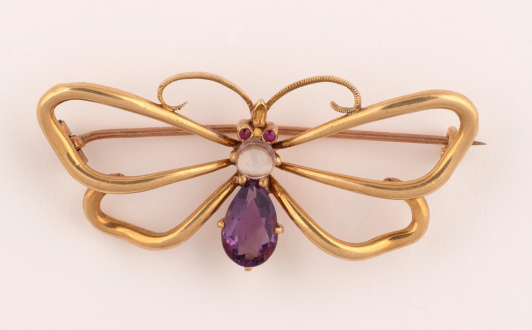 The thorax and abdomen formed as a pear-shaped amethyst, the head set with an round moonstone, between fluted wings.
Width 3.7cm