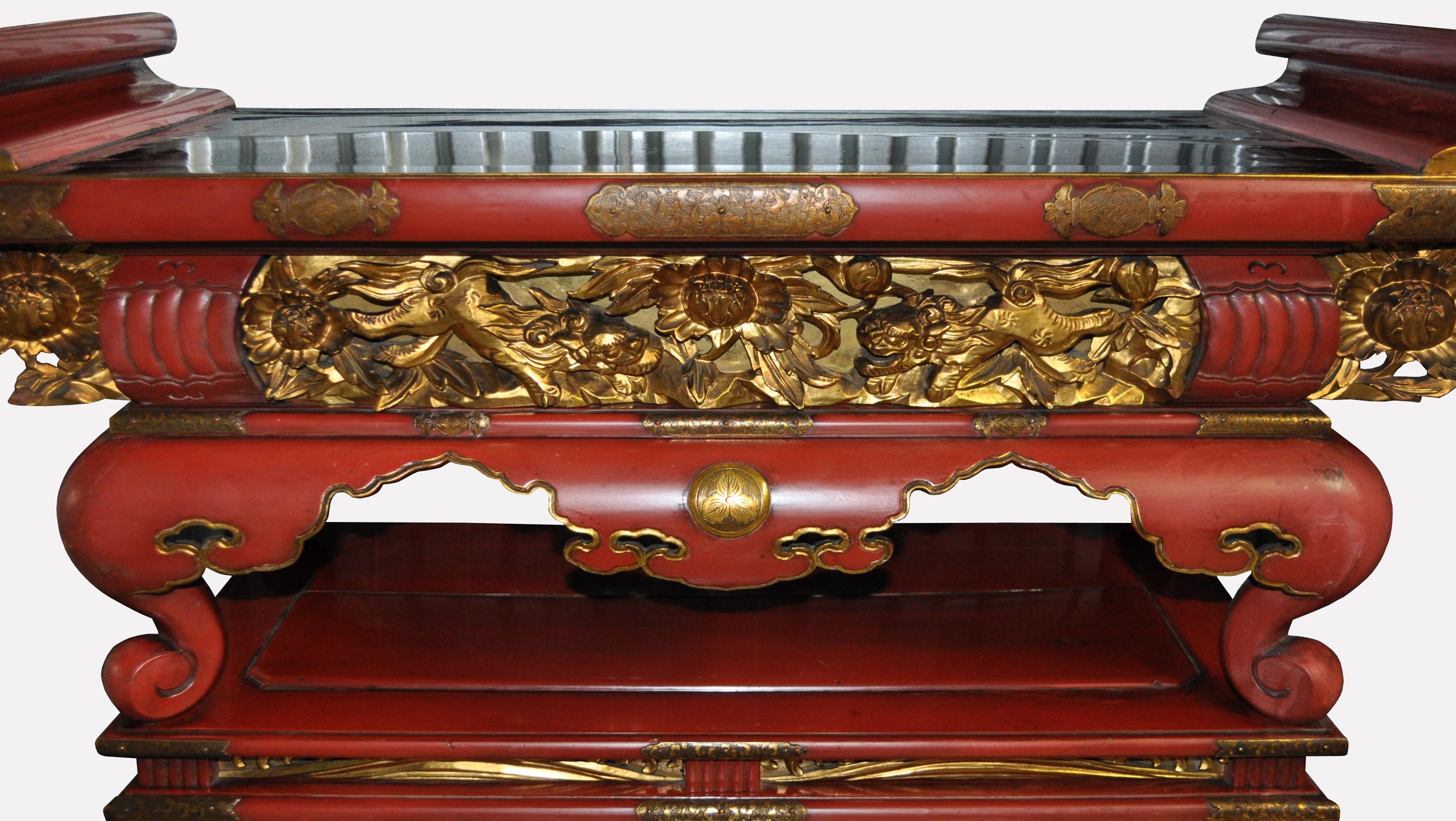 A rare antique Japanese altar table of stunning red lacquer with hand engraved gilt bronze fittings. Calligraphic inscription on the surface is a commemorative dedication naming the families who commissioned the creation of this altar for the