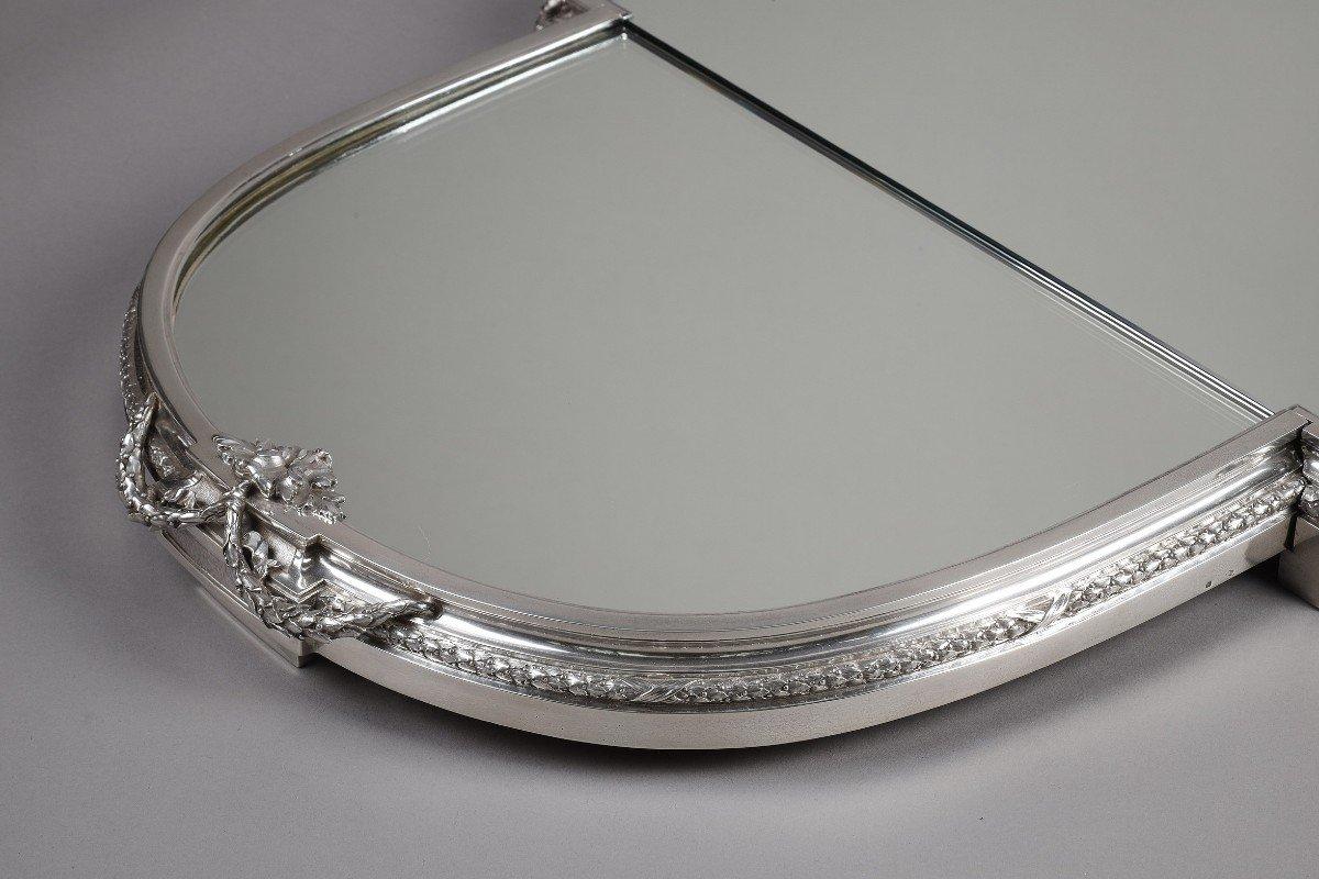 Principalmente mesa en tres partes con fondo de espejos, sobre un parquet de roble, rodeada por una gran lingotera de plata maciza decorada con un friso de laureles y guirnaldas de estilo LOUIS XVI.

Dimensiones: longitud 116 cm - anchura 57 cm -