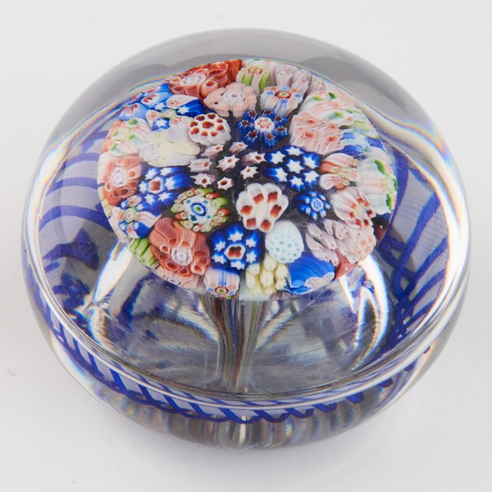 Heading : A baccarat mushroom torsade paperweight circa 1850.
Date : 1850.
Origin : France.
Features : A closepack of multple canes in mushroom form with an outer blue and white torsade
Marks : None.
Type : Lead.
Size : 7.7 cm