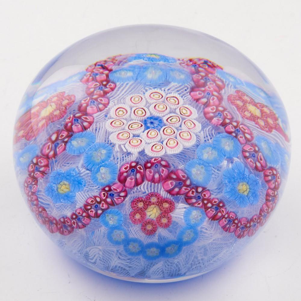 A Baccarat Trefoil Millefiori Garland Paperweight, 1971

Additional information:
Date : 1971
Origin : France
Features : A trefoil garland of red canes interspersed with six complex canes on a muslin base with blue ground and concentric centre
Marks