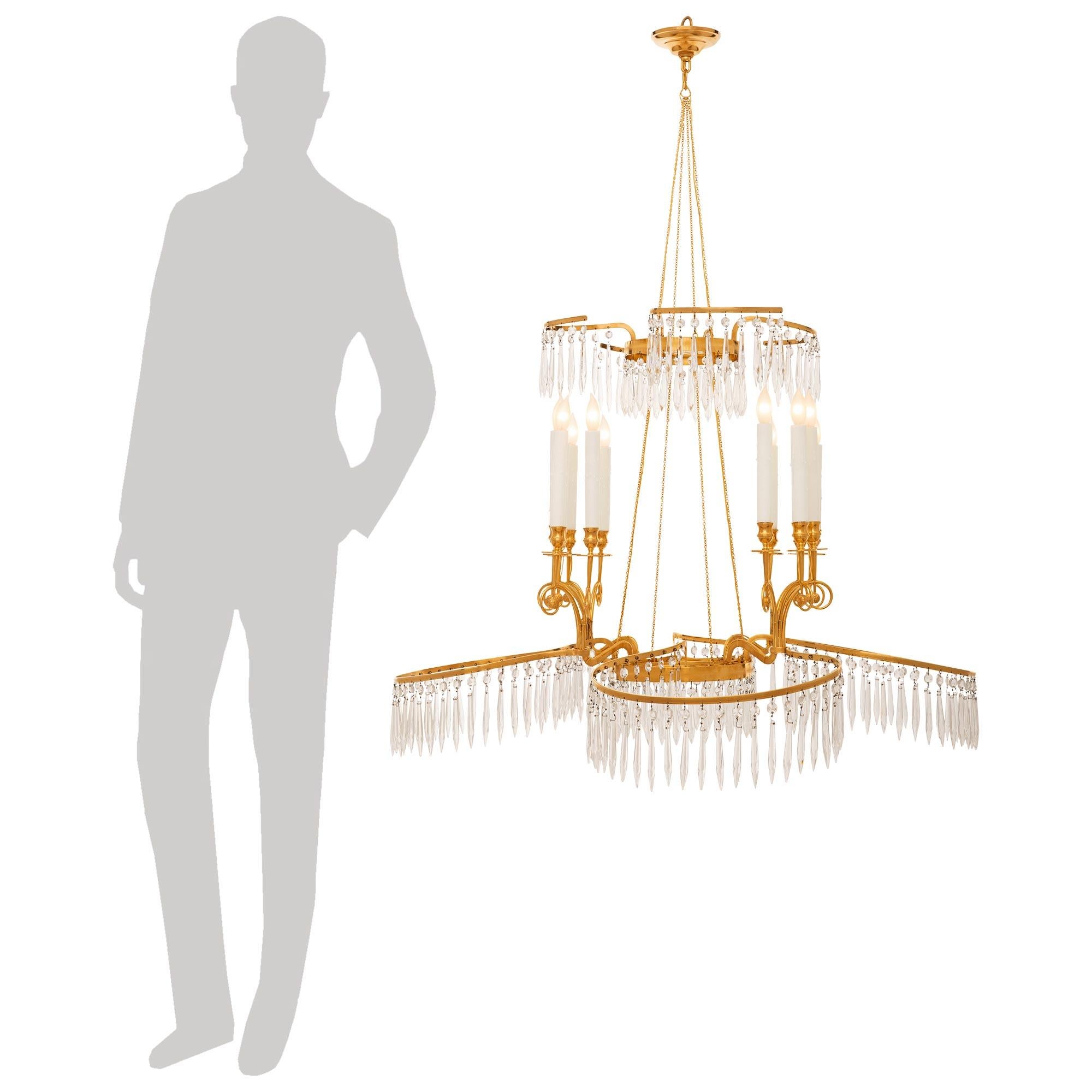 

A most elegant and finely decorated Baltic 19th century Neo-Classical st. Crystal and Ormolu chandelier. This stunning twelve arm twelve light chandelier is centered by a circular Ormolu base with prism cut pendants hanging below that supports the