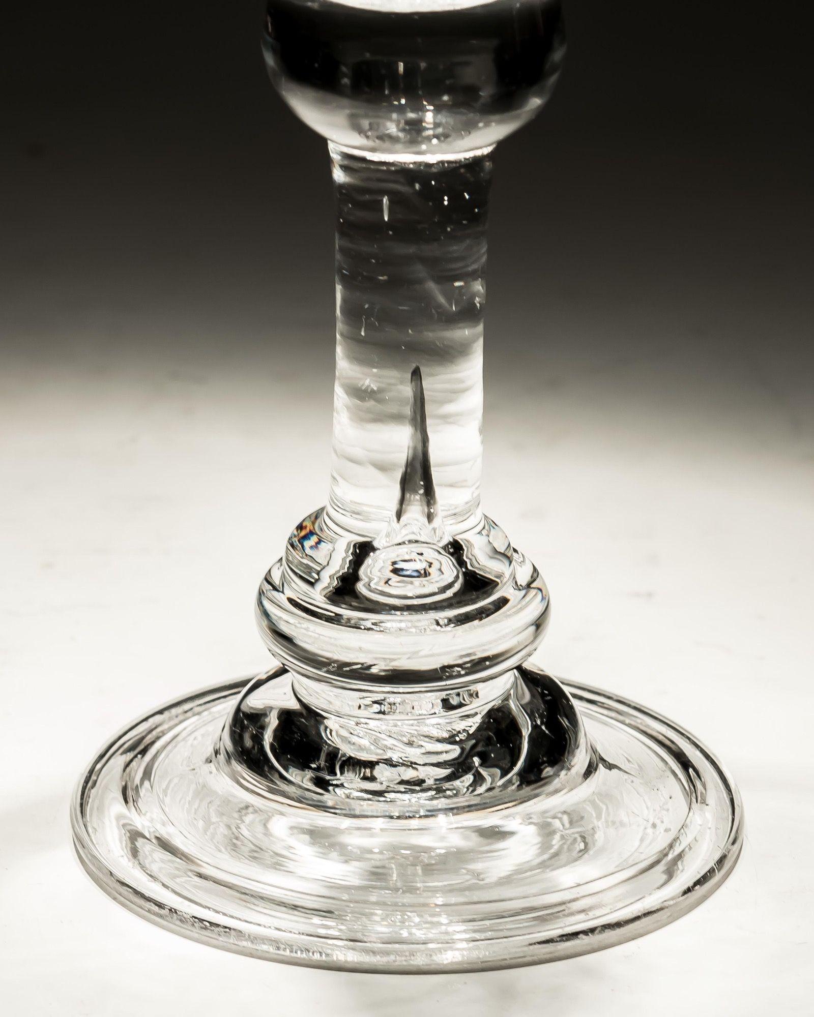 A baluster wine with flared bowl, above a straight section with annulated knop, on a domed and folded foot.