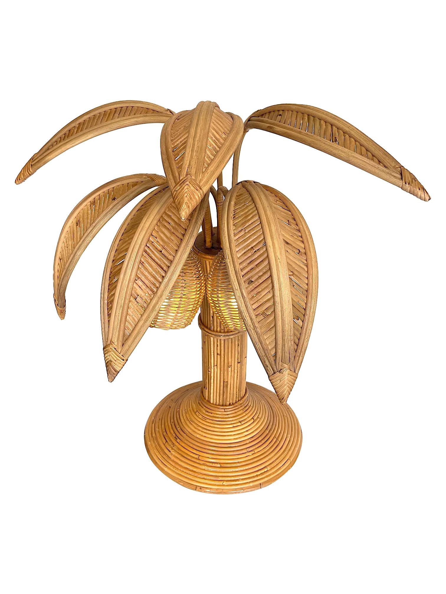 A bamboo palm tree table lamp in the style of Mario Lopez Torres with two coconut lights under the leaves.