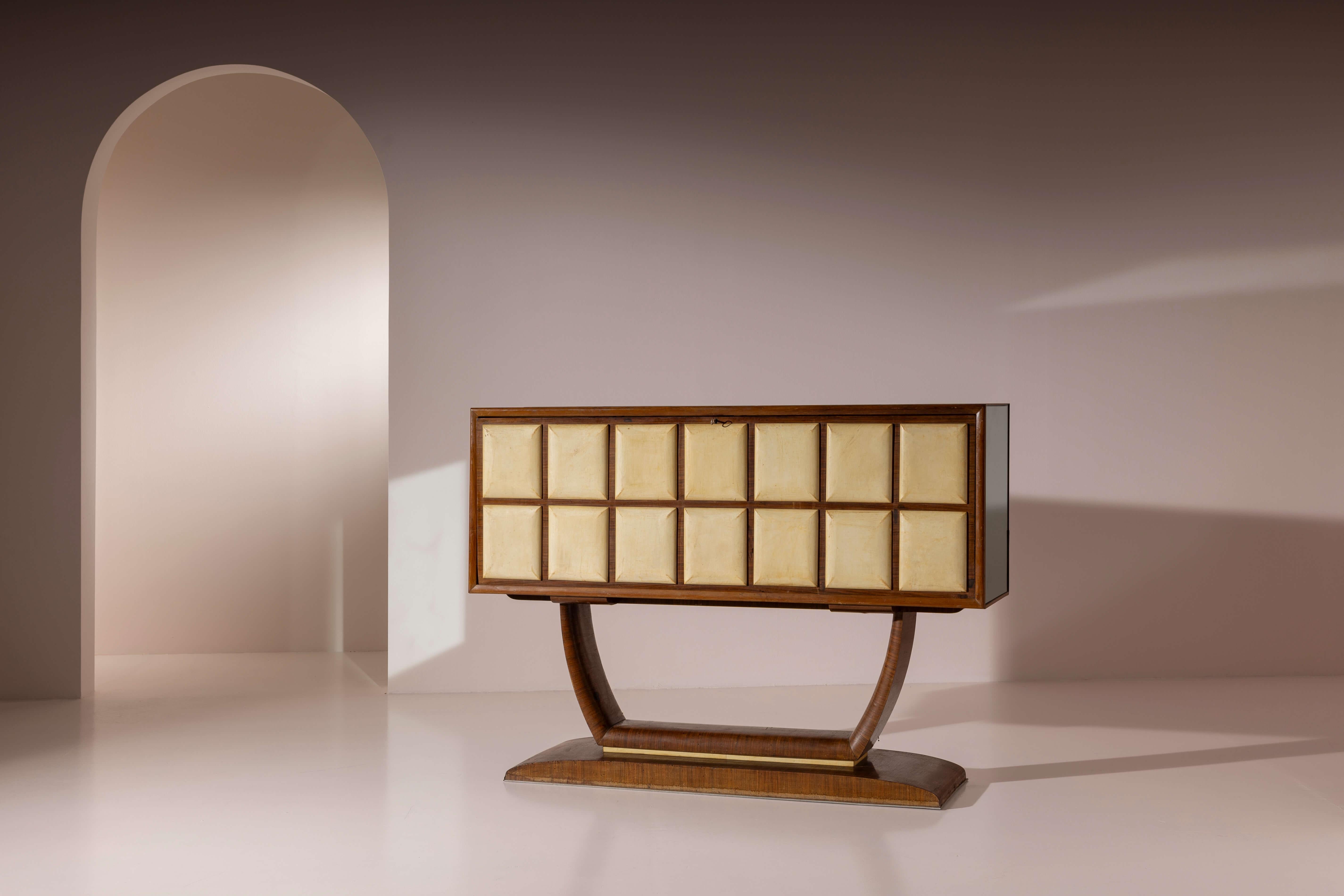 A large bar cabinet in wood, parchment, glass and mirrors, Italian manufacture, 1940s

Suspended on a slender base that appears to support it effortlessly, this bar cabinet is distinguished by the elegant sequence of decorative panels along its