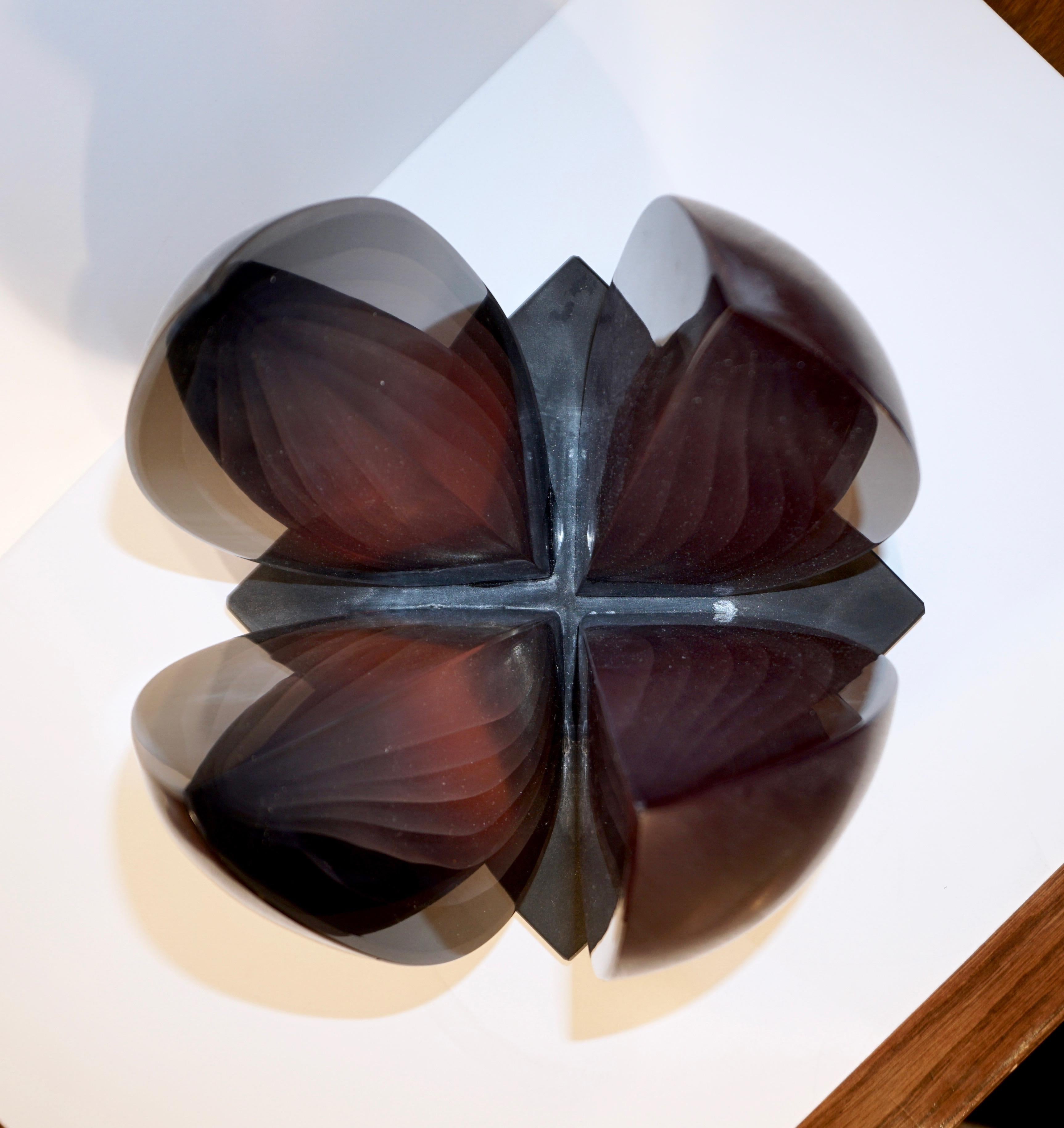 Minimalist abstract sculpture in a dark plum color composed of 4 cloves, realized with the Sbruffi technique in 7 layers of various color intensities that each catches the light differently, overlaid in a darker glass with matt finish, raised on a