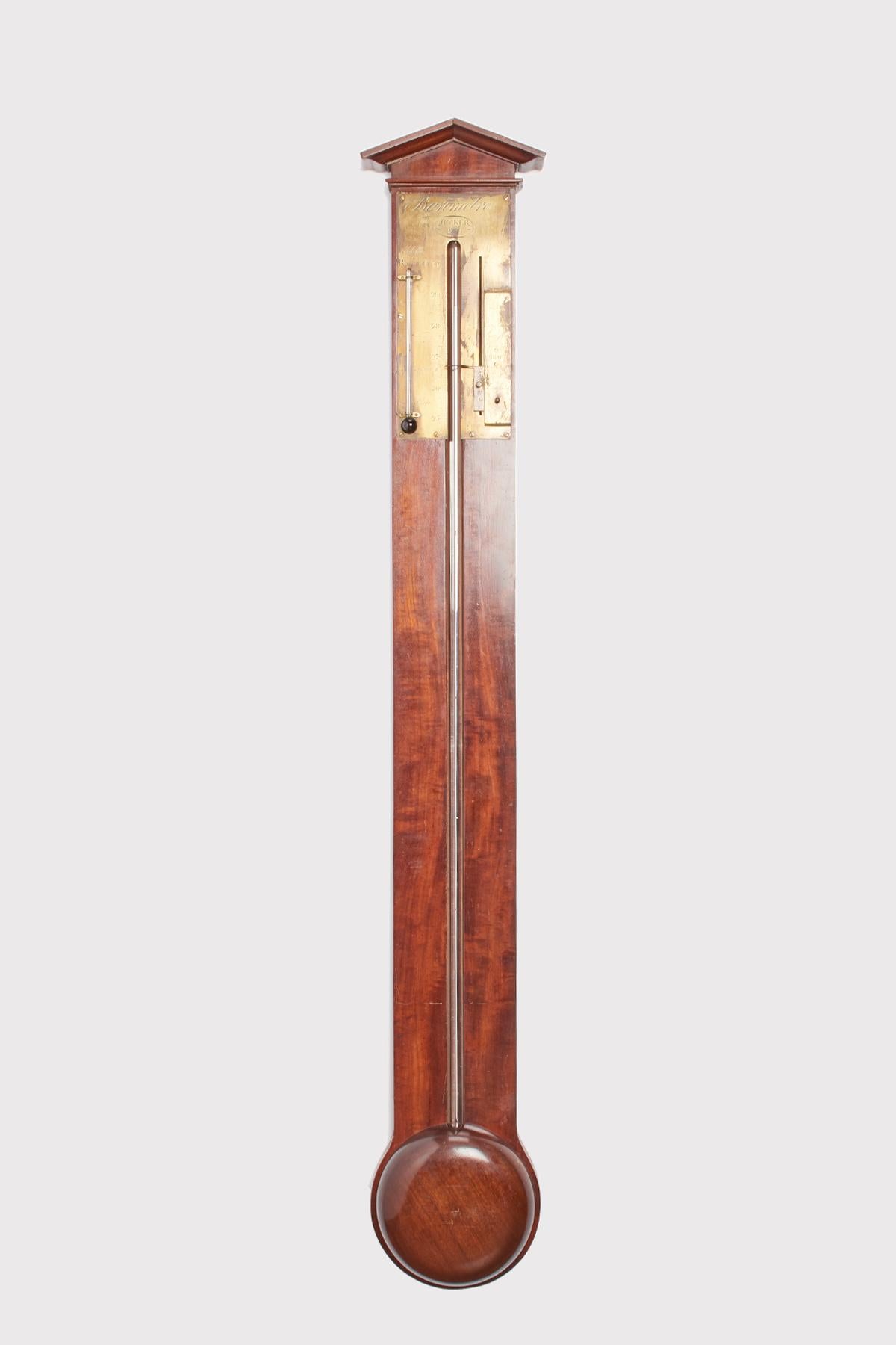 Antique mahogany wall barometer composed of a glass tube containing mercury with its reserve. On the upper part a gable-shaped pediment and a screwed brass plate with a small alcohol thermometer and a movable brass index for the barometer.
The brass