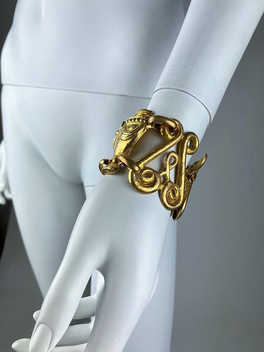 Circa 1940-1950

France

Elegant Haute Couture bracelet by Marcel Rochas (1925-1955) in baroque style in gilt metal. Neoclassical inspiration with draped Greek amphorae, linked by lyres in a graphic design typical of the decorative arts of the