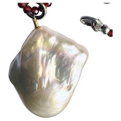 A Baroque South Sea Pearl Pendant hanging from a 24 Inch Beaded Garnet Necklace