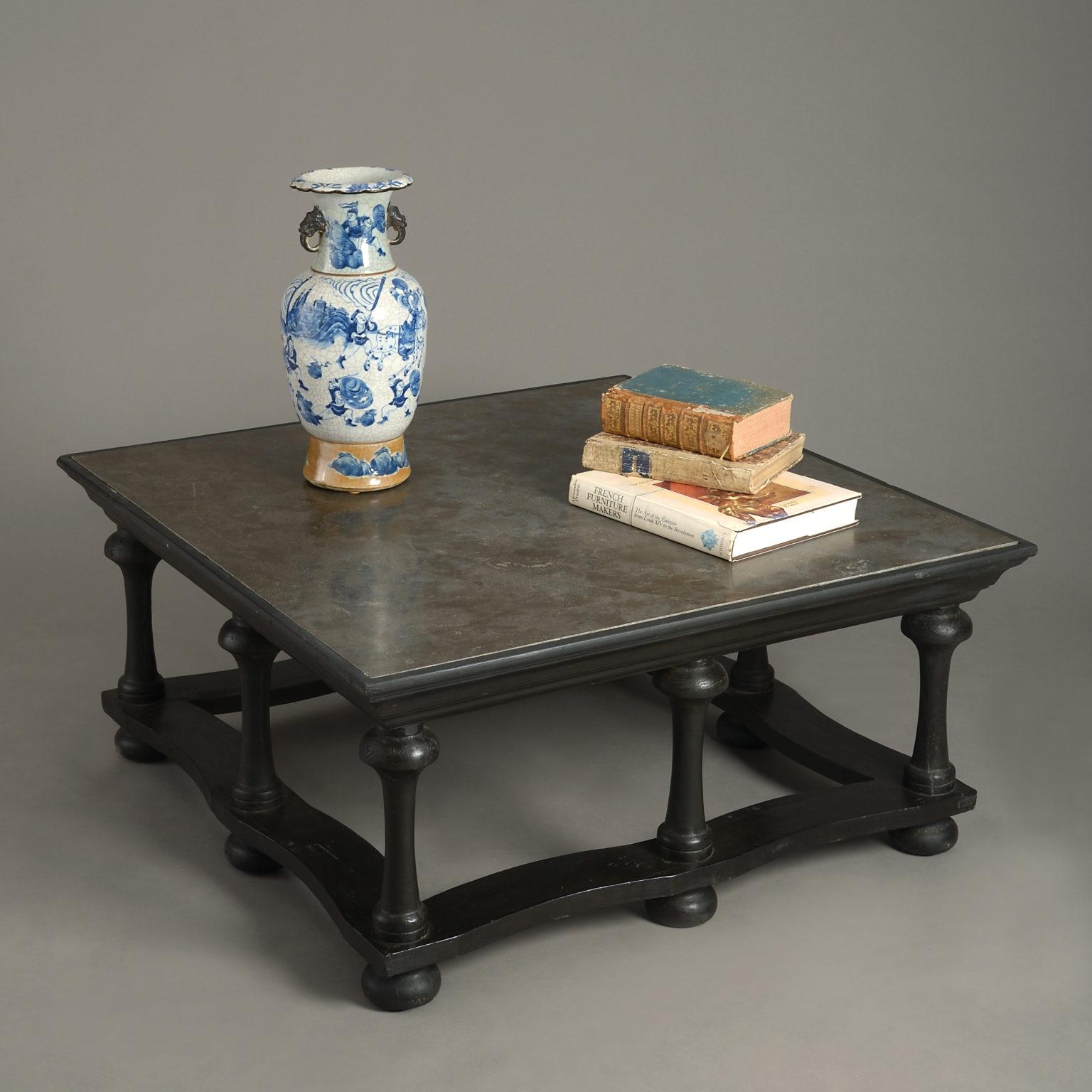 A 20th century low table of square form, in the Early Baroque manner, having a marble top inset, the ebonised base of turned baluster supports, joined by shaped stretchers and raised on bun feet.
     