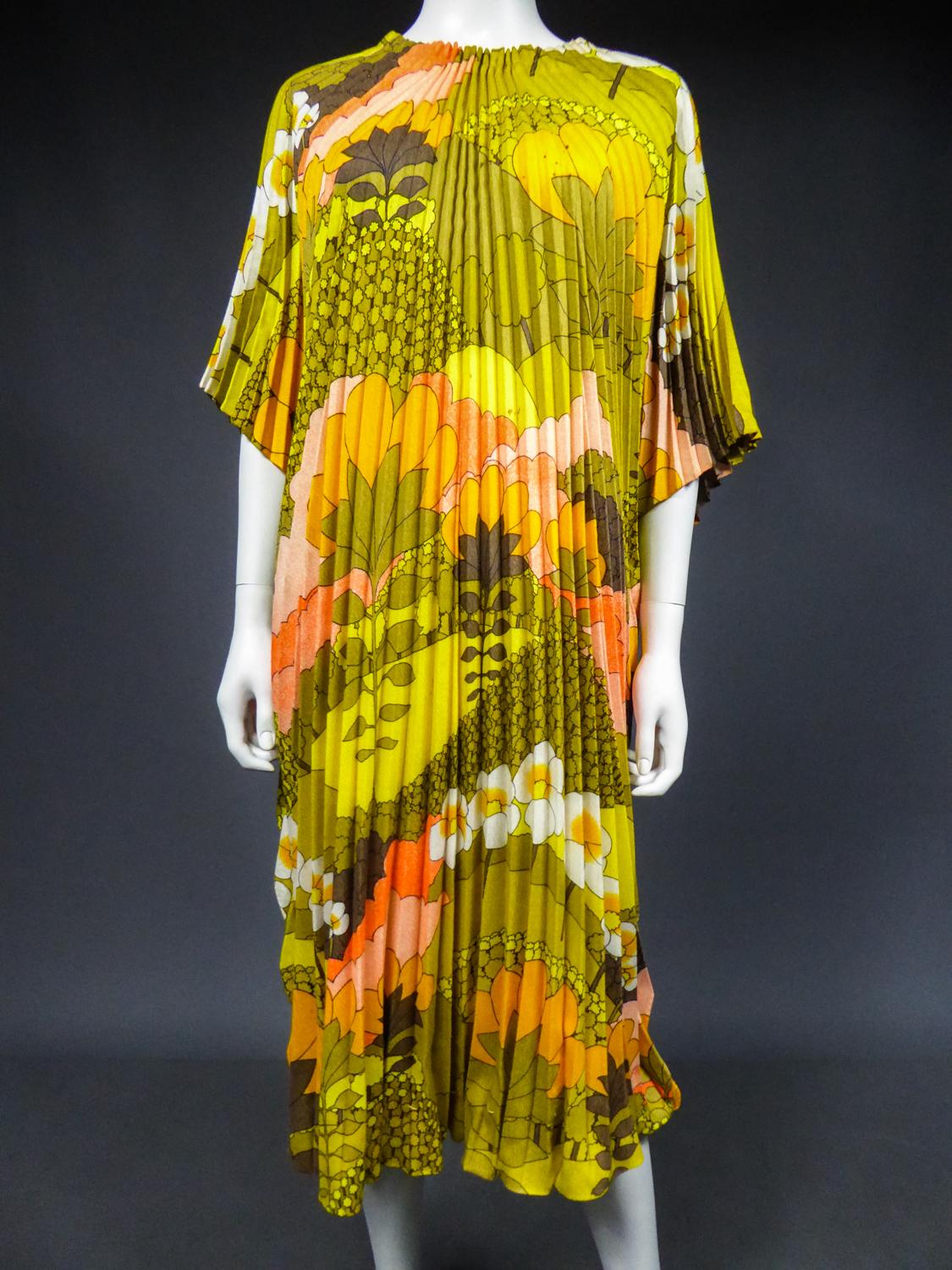 Circa 1970
France

Psychedelic beach dress or tunic in printed polyester cotton with vegetal motifs (daisies, palm leaves, etc.) in green, khaki, yellow, orange, red and white tones from the 70s by Georgie Keyloun. Kimono tunic with wide opening for