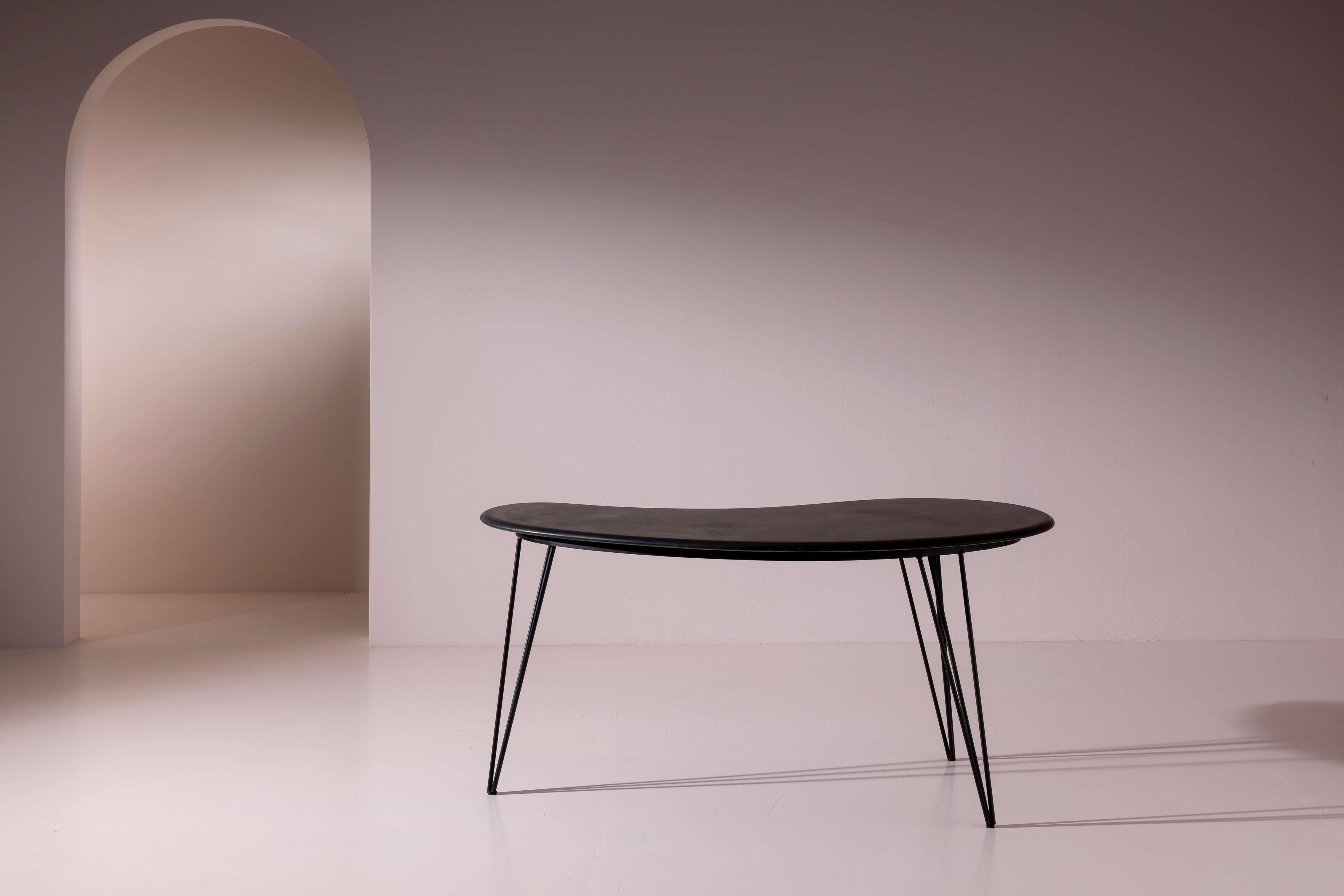 Questo tavolo scultoreo a forma di fagiolo cattura lo spirito sperimentale del design italiano della fine degli anni '50, dove la forma organica incontrava la materialità moderna. La sua silhouette - fluida, asimmetrica e sensuale - evoca le