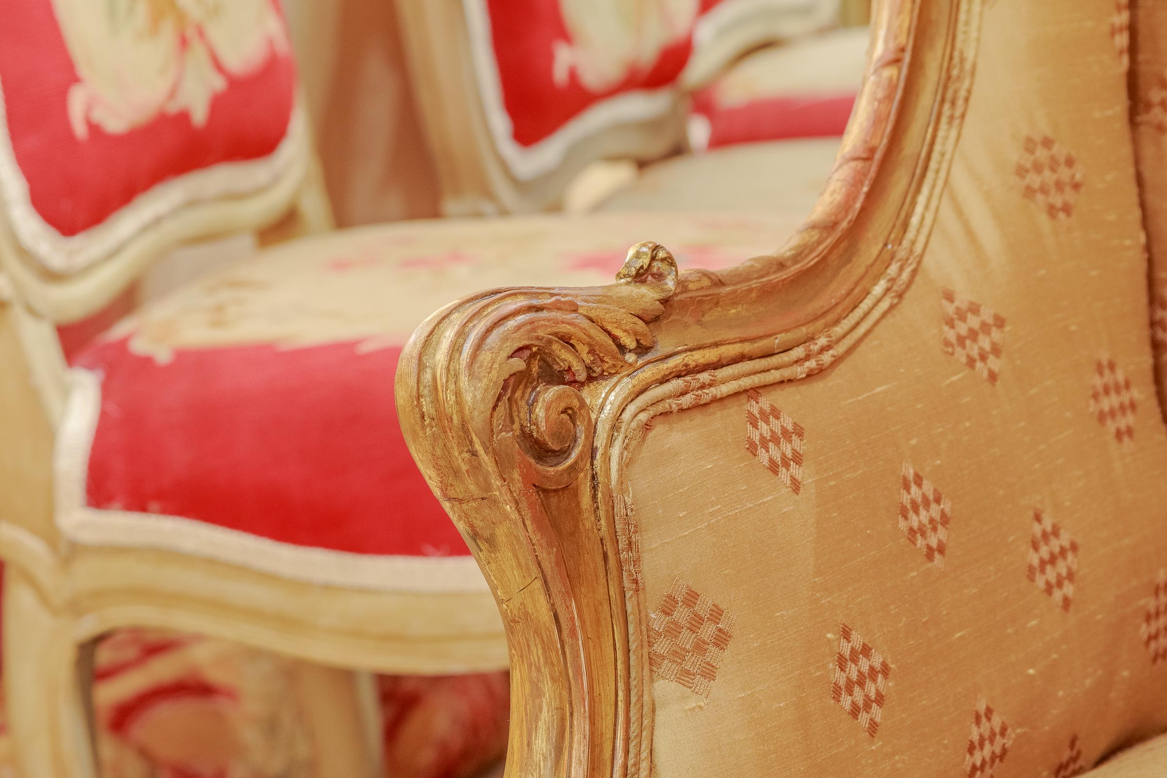 A finely hand carved 19th century French Louis XV gilt bergère. Covered in a gold silk blend material.