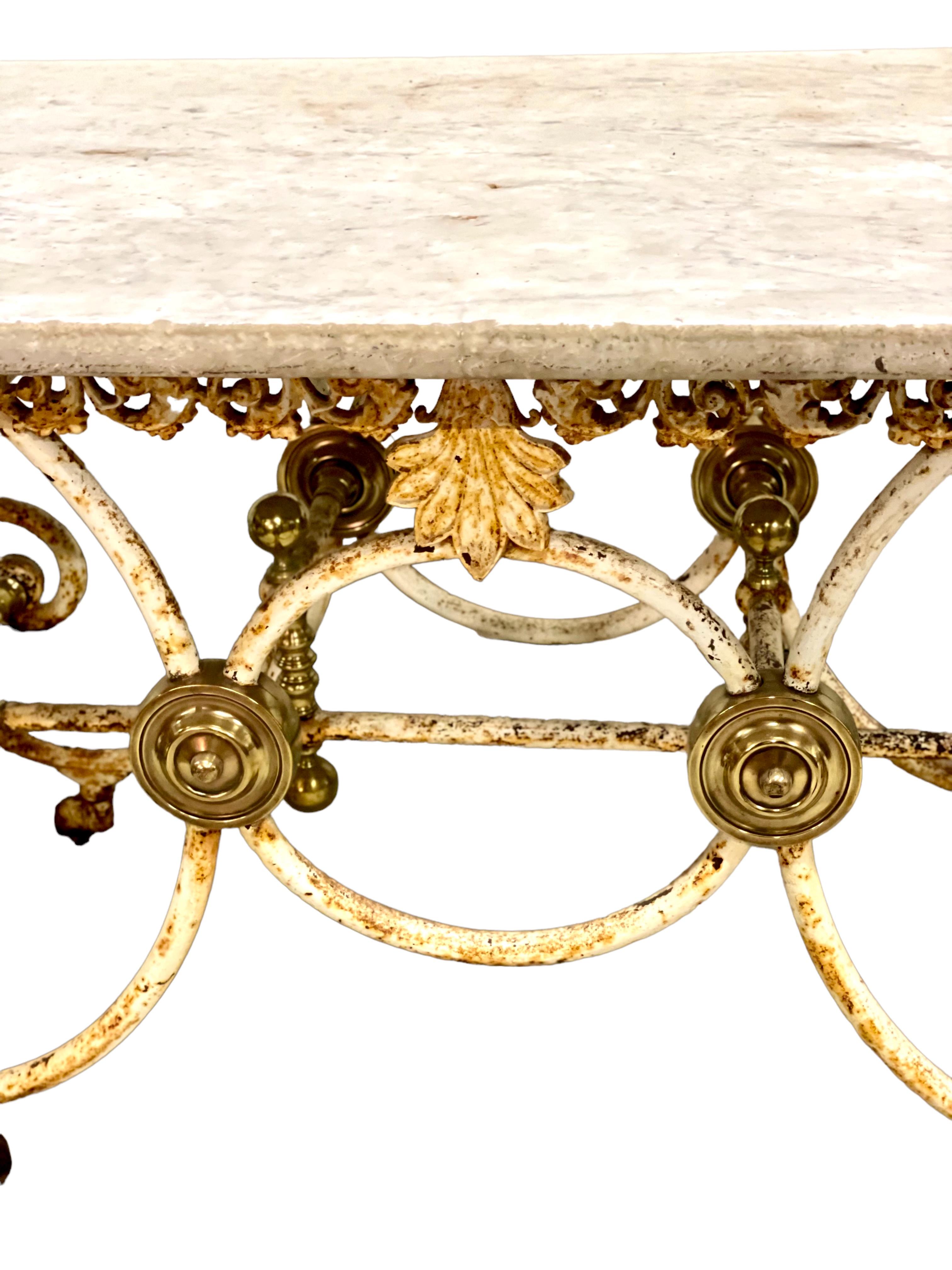 Cette exceptionnelle table à pâtisserie (ou à boucherie) du XIXe siècle, en fonte laquée et laiton doré, est dotée de grands pieds A.I.C. et de brancards en fer forgé reliant chaque extrémité. Le plateau est en marbre d'origine, avec quelques bosses