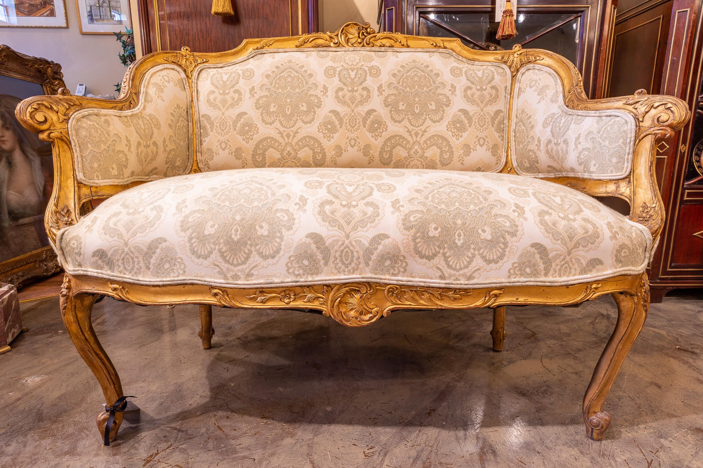 A fine small 19th century French Louis XV gilt hand carved settee. Fine gilding and detail.