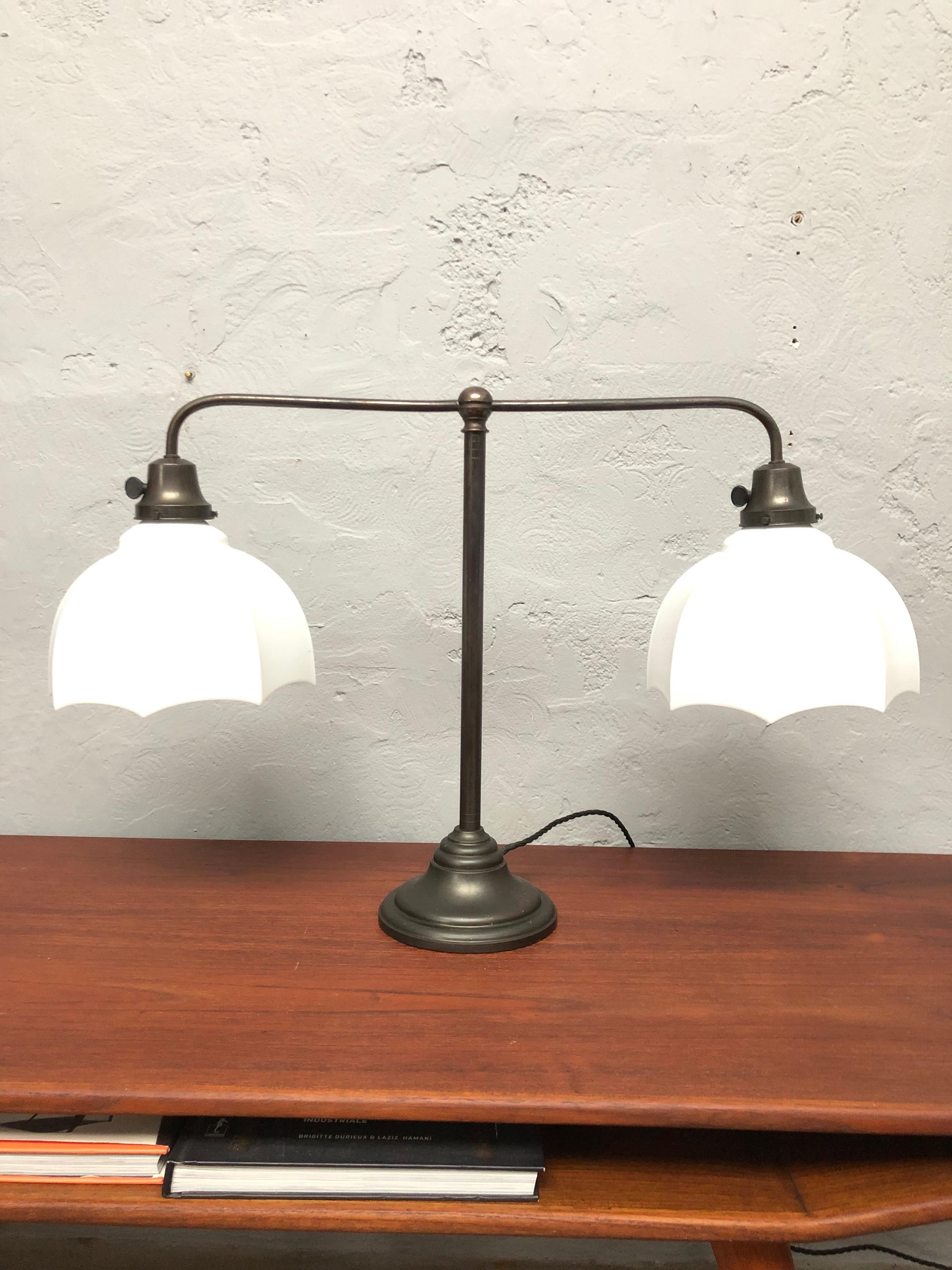 A beautiful antique Danish library table lamp in brass and with opaline shades.
The brass has a lovely patina to it something that only time can create. 
Two opaline glass shades mounted onto brass galleries and held by three brass thumb screws.