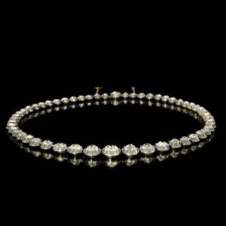A beautiful Victorian rivière diamond necklace c.1880, set with fifty four old mine brilliant cut diamonds in silver cut down collets backed with gold, the graduated diamonds estimated to weigh a combined total of approximately 20.7cts, to a