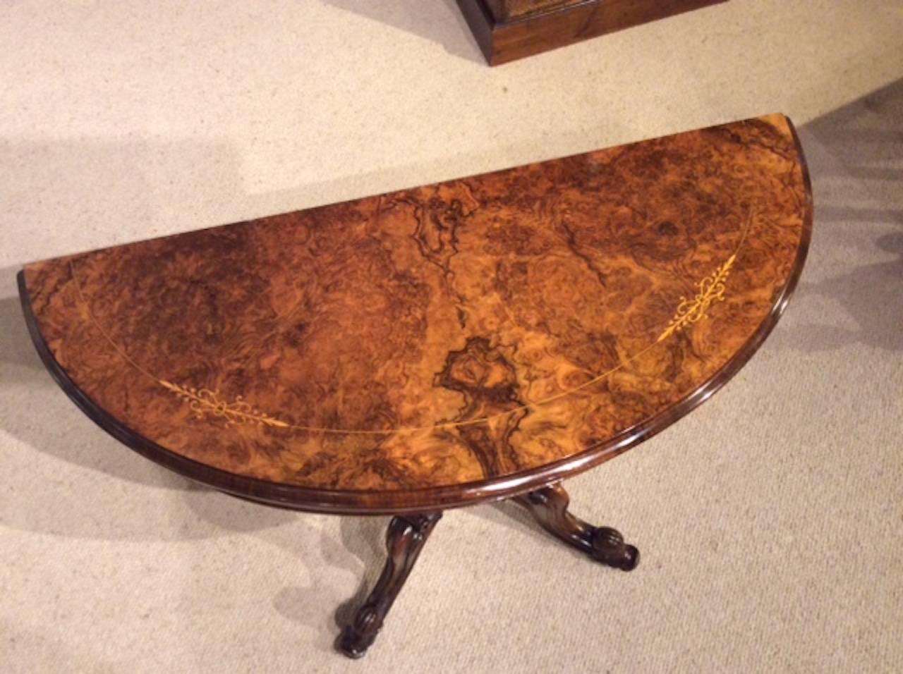 A beautiful burr walnut and marquetry inlaid Victorian period fold over card table. Having a demi lune top veneered in beautifully figured burr walnut with foliate boxwood marquetry inlay, which swivels and opens to reveal a baize lined playing