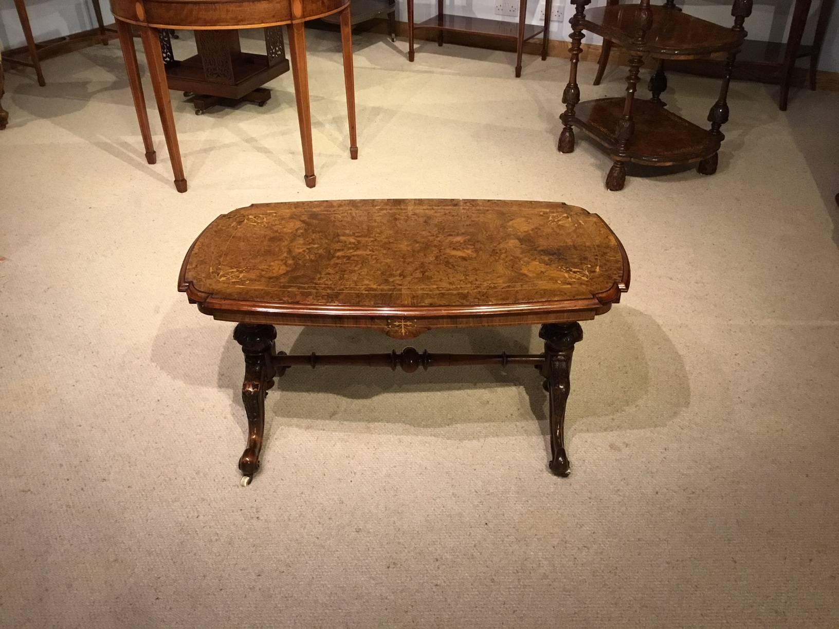 A beautiful burr walnut inlaid Victorian period antique coffee table. Having a rectangular top veneered in beautifully figured burr walnut with re-entrant corners and fine floral marquetry inlaid detail. With a walnut moulded edge and shaped frieze,