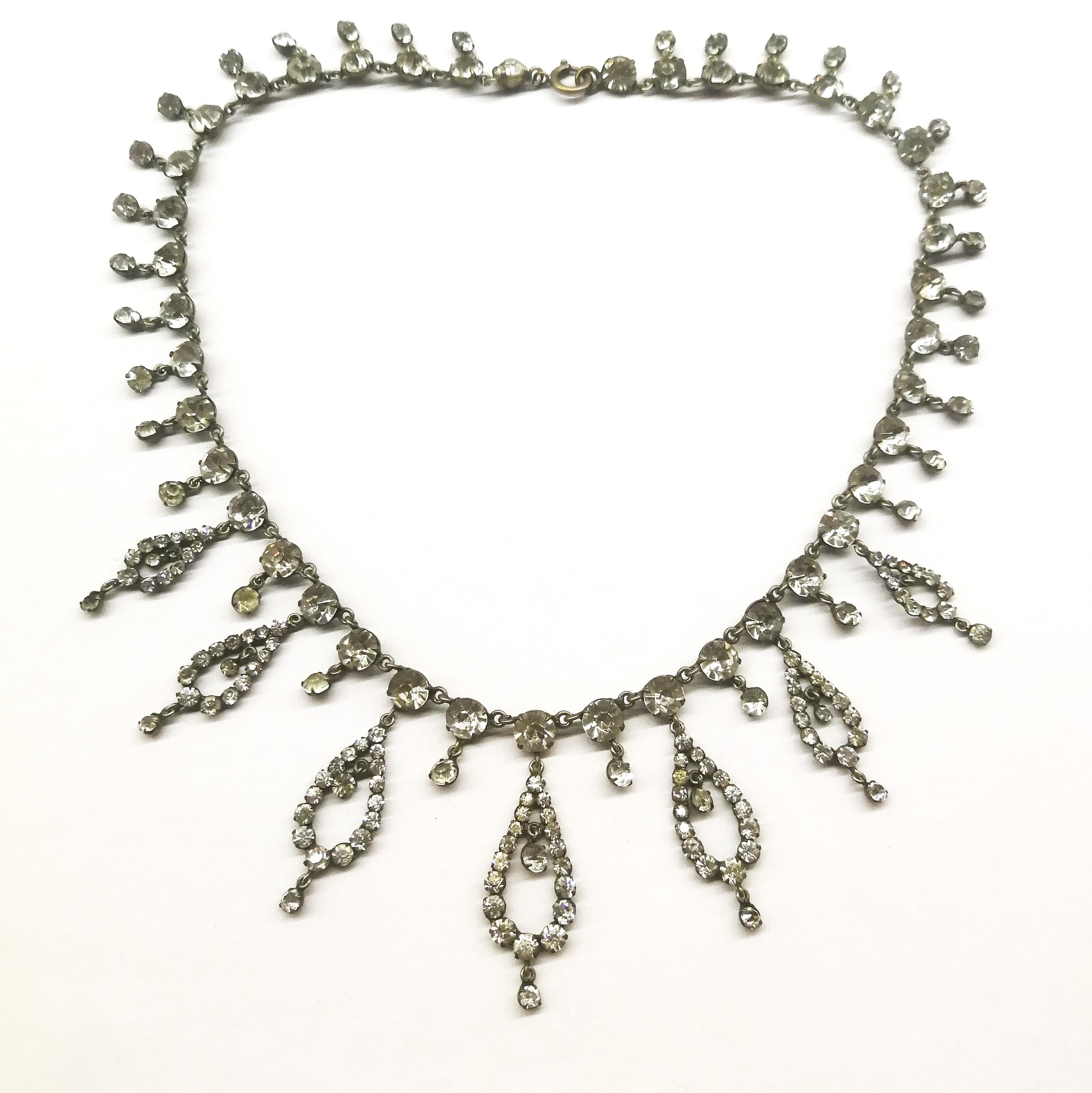 A beautiful period necklace, delicate and fine, with graduated stylised paste drops, each moving and articulated, and individual small pastes that drop down along the length of the necklace. Made from base metal and clear pastes, most likely French