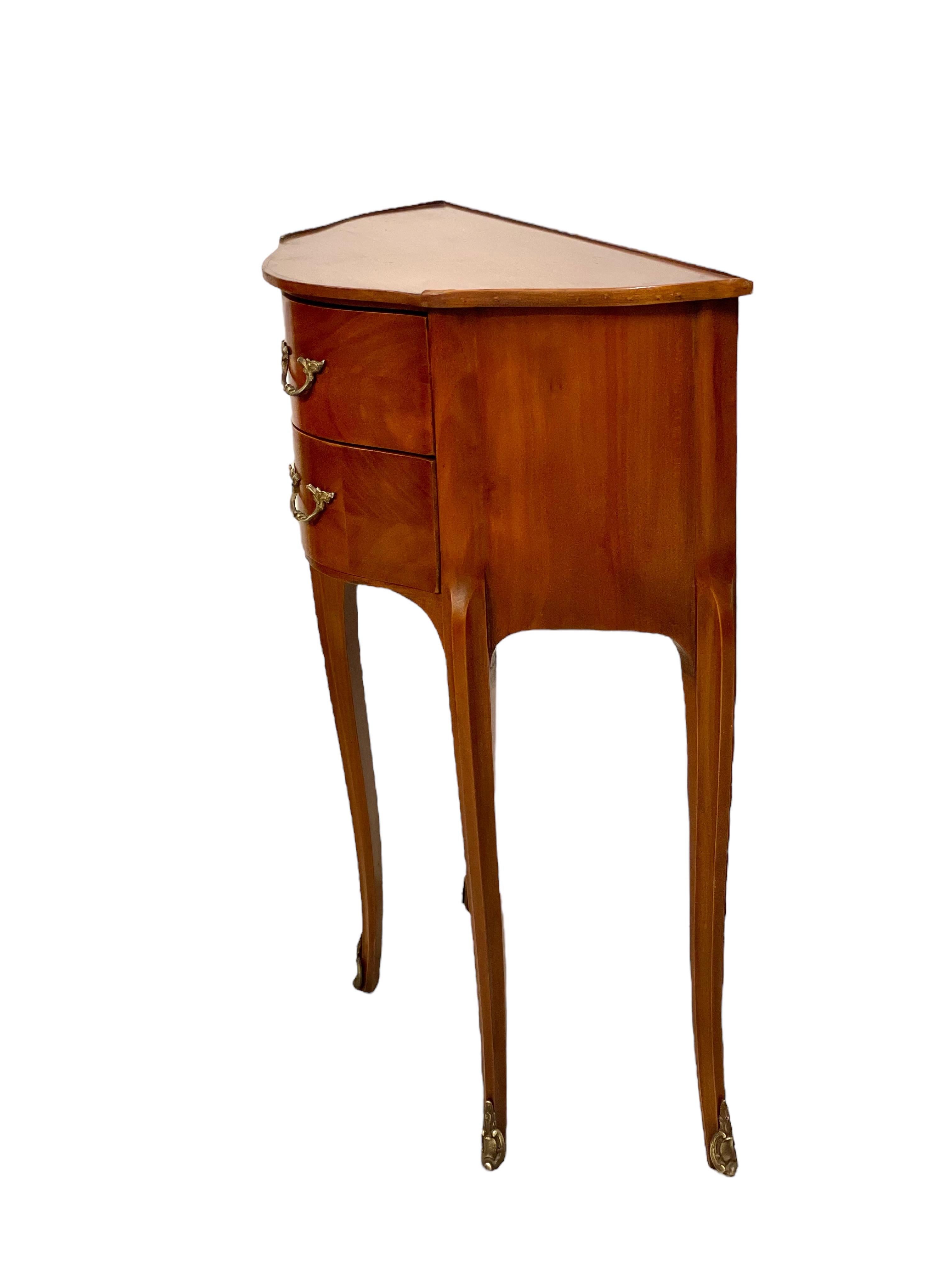 A beautiful demi-lune bedside cabinet, with elegant serpentine front and two drawers. This practical and attractive commode echoes the Louis XV style, and features two capacious drawers, a polished wooden top, and is raised above curving cabriole