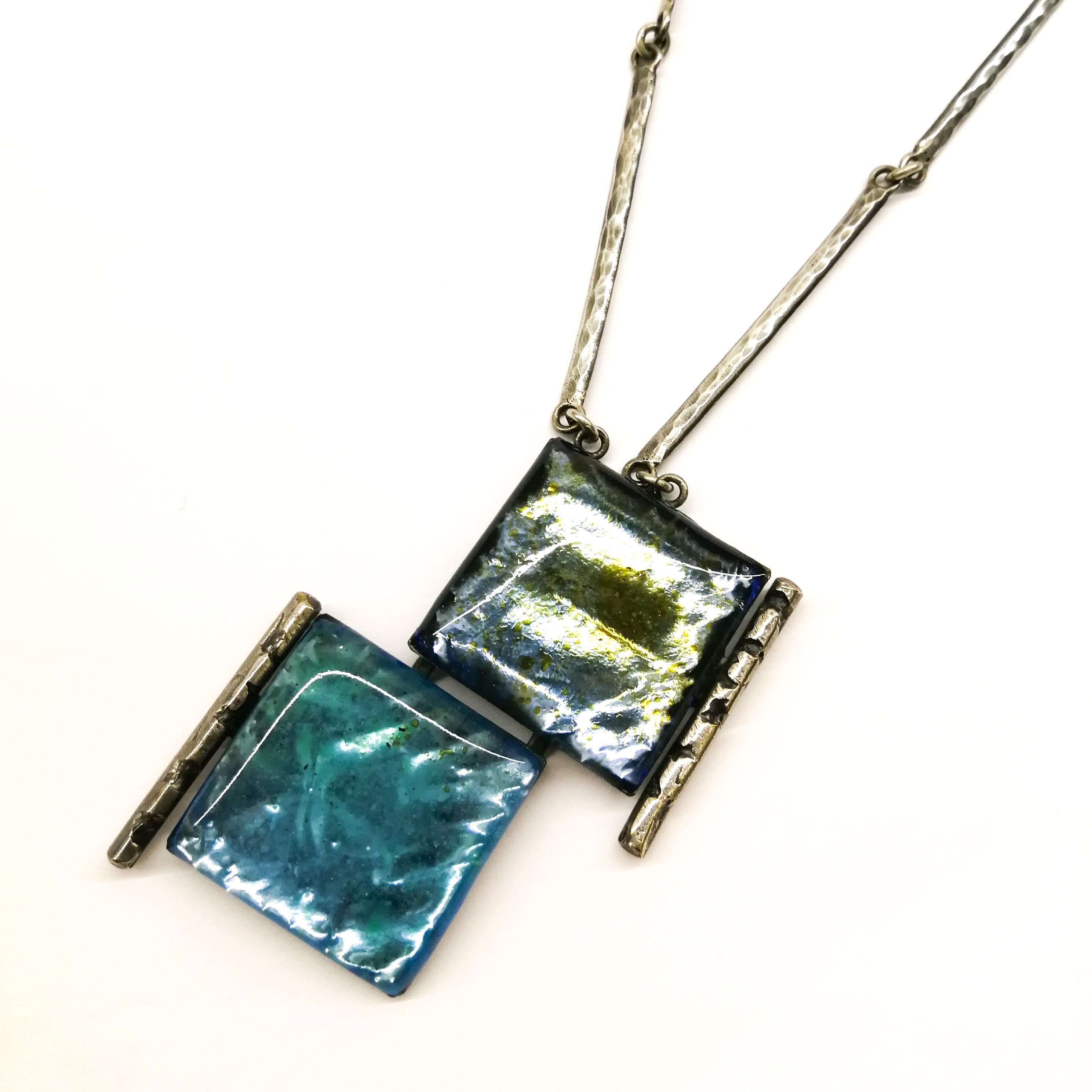 Two subtle, contrasting shades of blue enamel make this pendant hand crafted by Jacques Gautier eye-catching and  appealing, a watery aquamarine blue next to a grey darker blue. Highly typical of the exquisite work of Jacques Gautier, the metal work