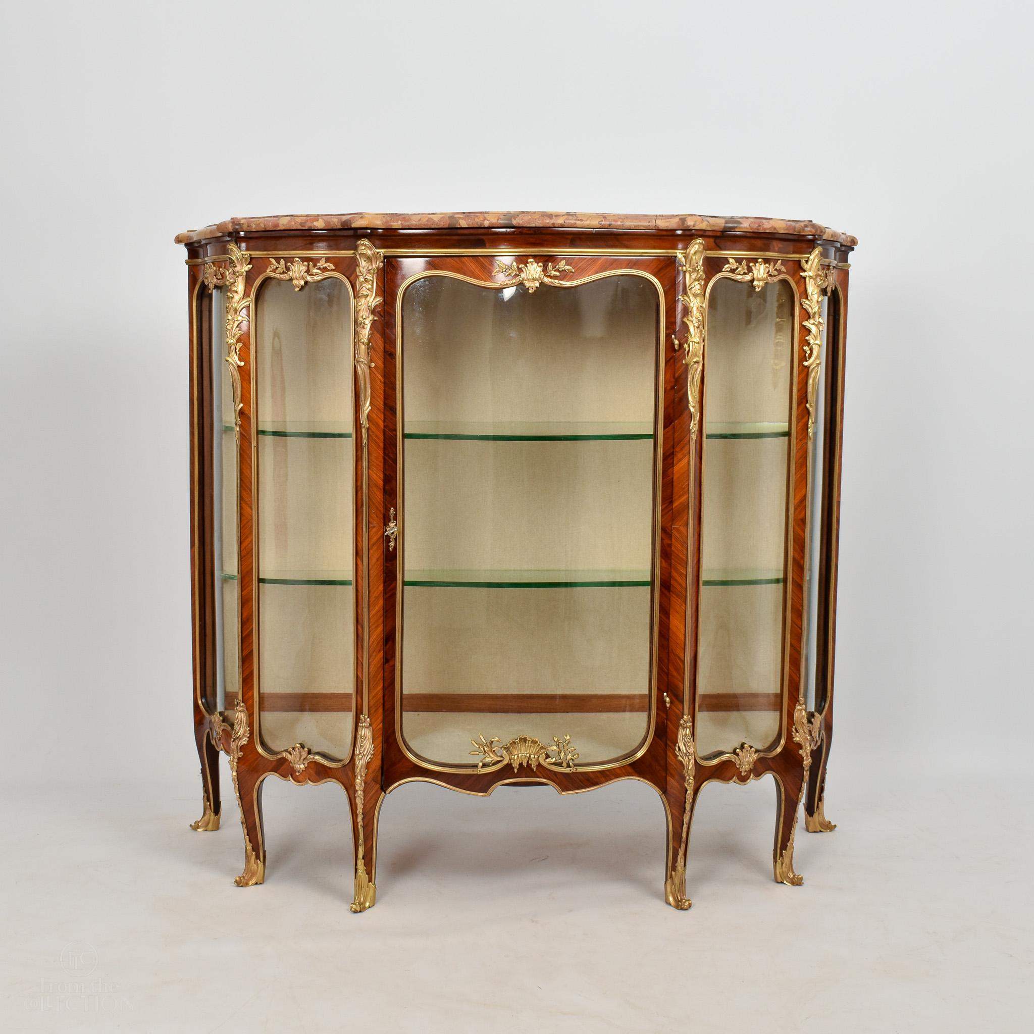 A beautiful French Kingwood Vitrine circa 1890 of exceptional colour and quality with gilt bronze mountings and two shaped glass shelves, glass panels to the side and one door to the front. The piece is of exceptional quality in every aspect, and in