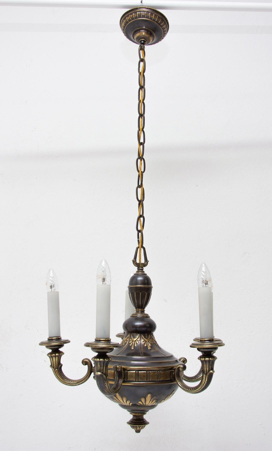 A beautiful brass five-armed chandelier in a historicizing style from the turn of the 19th and 20th centuries. It was made in the territory of the former Austro-Hungarian Empire. The chandelier is in excellent condition with a nice patina. It was