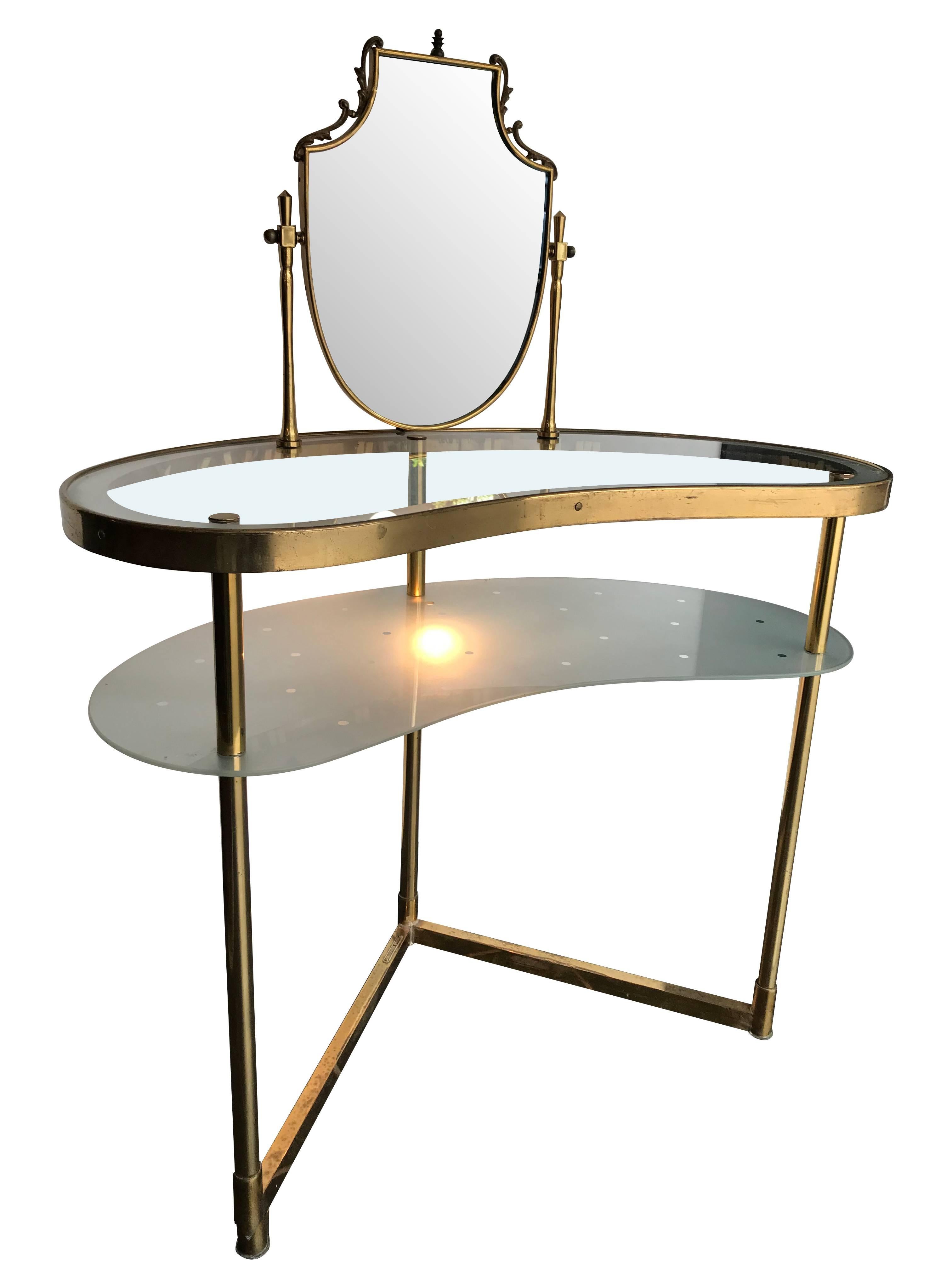 A beautiful Italian 1950s, kidney shaped vanity, dressing table, with brass frame.
The top shelf has frosted edge and the bottom shelf has a polka dot frosted pattern. There is still the original clips under the top shelf, which means that a