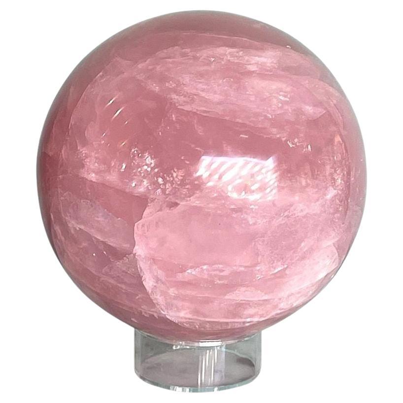 Preciosa esfera grande de cuarzo rosa pulido de Madagascar sobre soporte acrílico